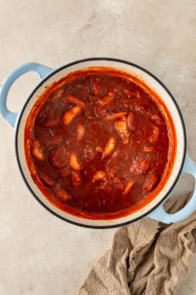 The tomato sauce and chorizo added into the pot.