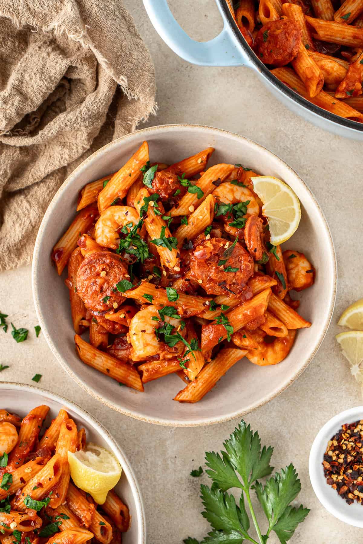 Prawn and chorizo pasta served into bowls with fresh lemon and parsley.