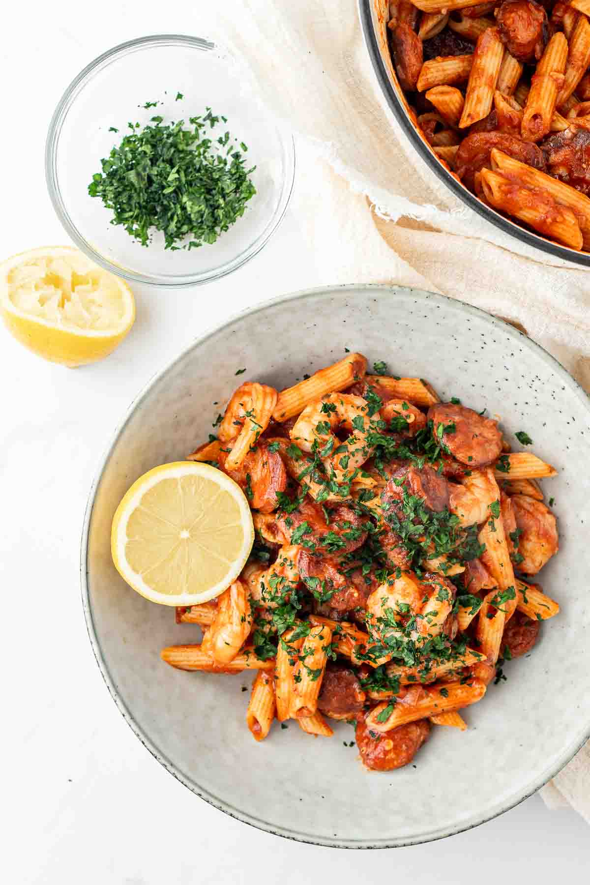 Prawn and chorizo pasta served in a bowl with lemon and parsley. 