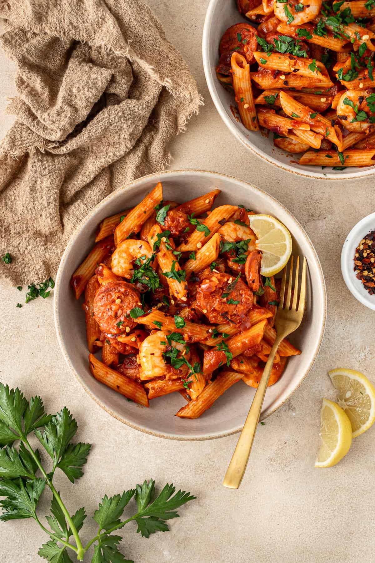 Spicy prawn and chorizo pasta served into bowls with parsley and lemon.