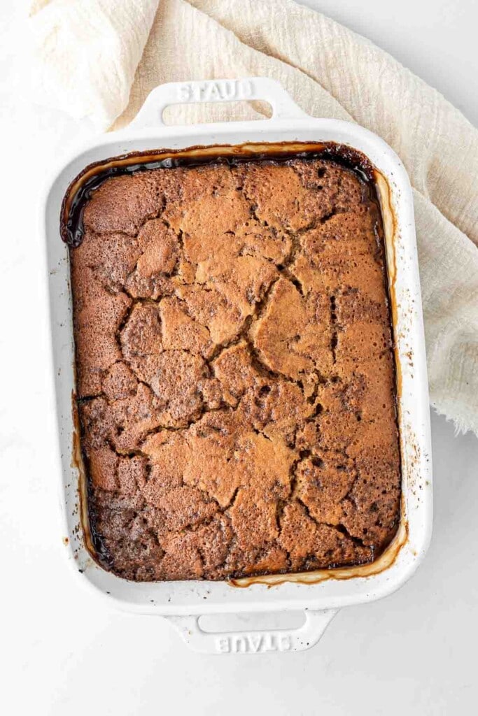 Freshly baked self saucing pudding in a rectangular white dish.