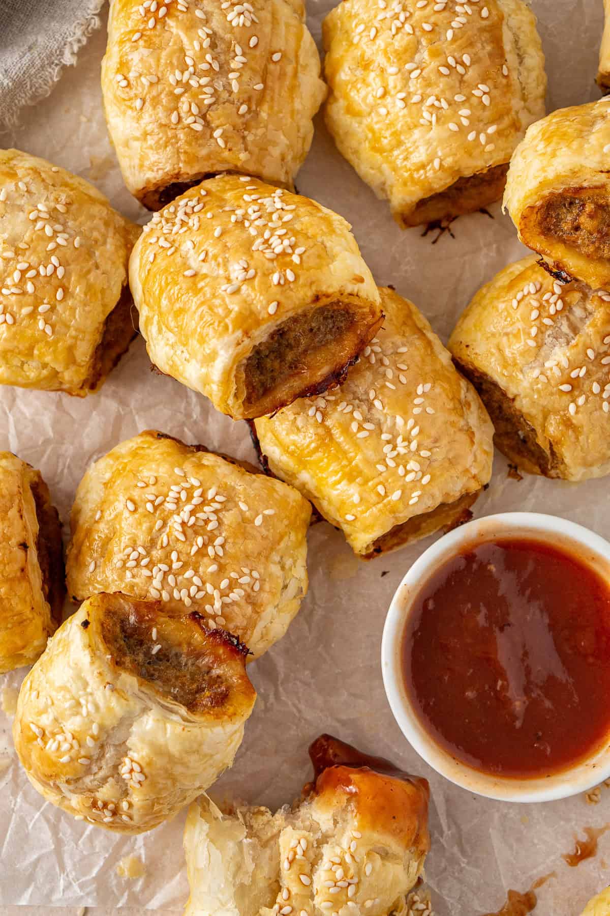 A plate of sausage rolls with tomato sauce. 