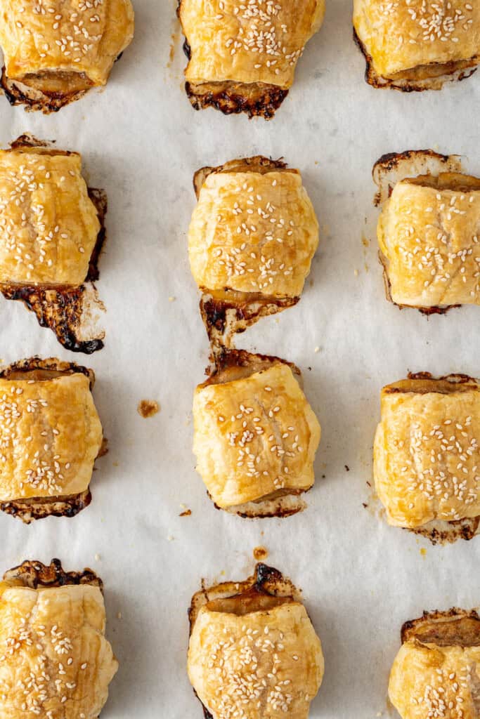 The cooked sausage rolls on a baking tray.
