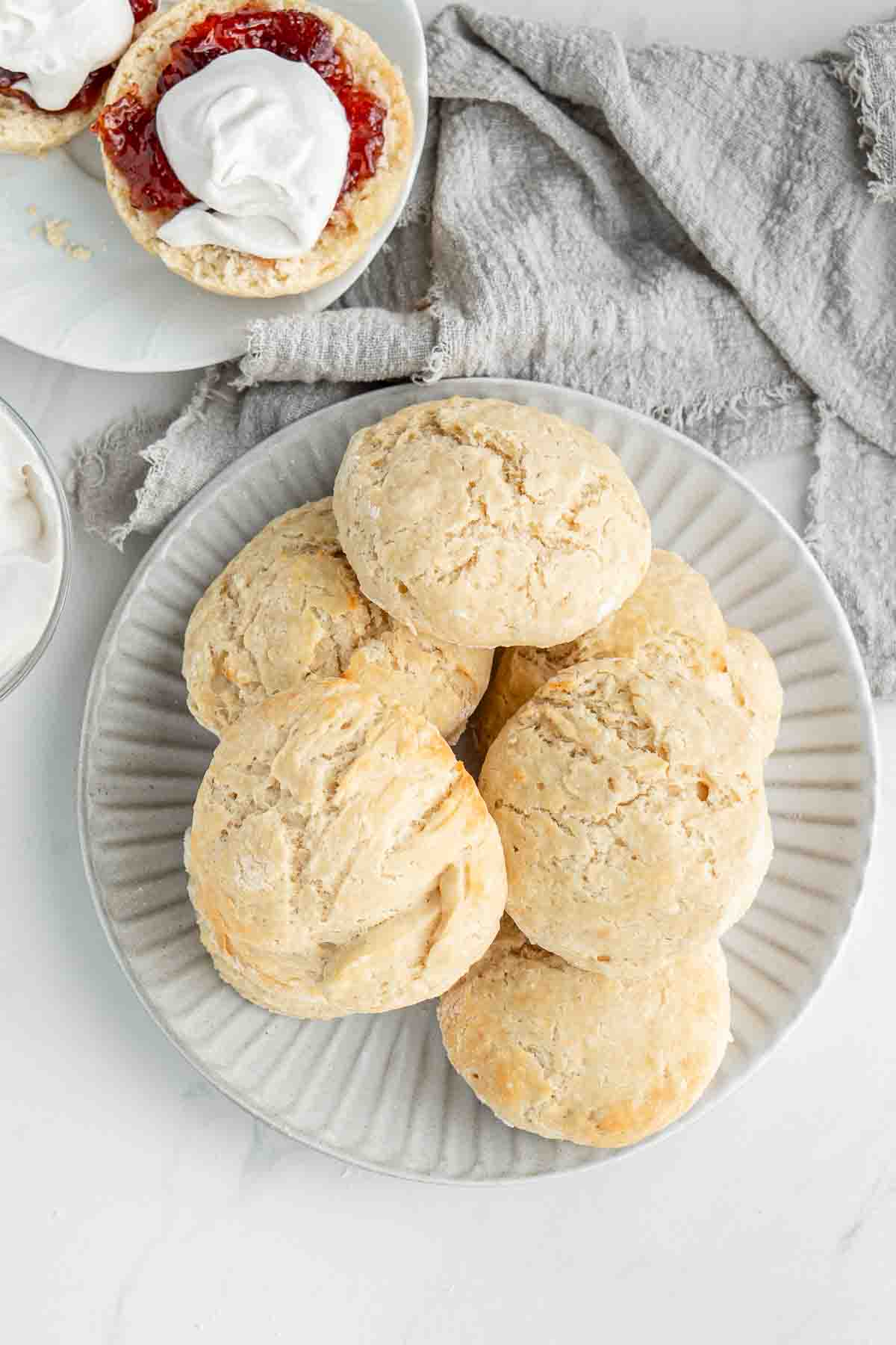 A pile of freshly baked scones on a white plate.