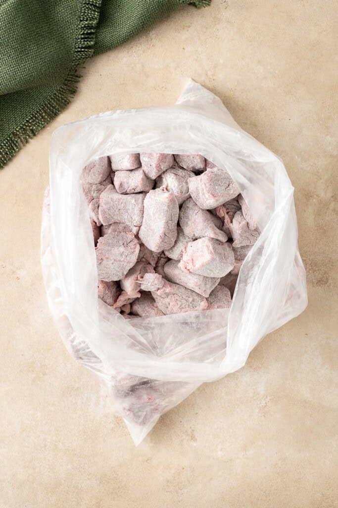 Coating the beef in the flour in a freezer bag.