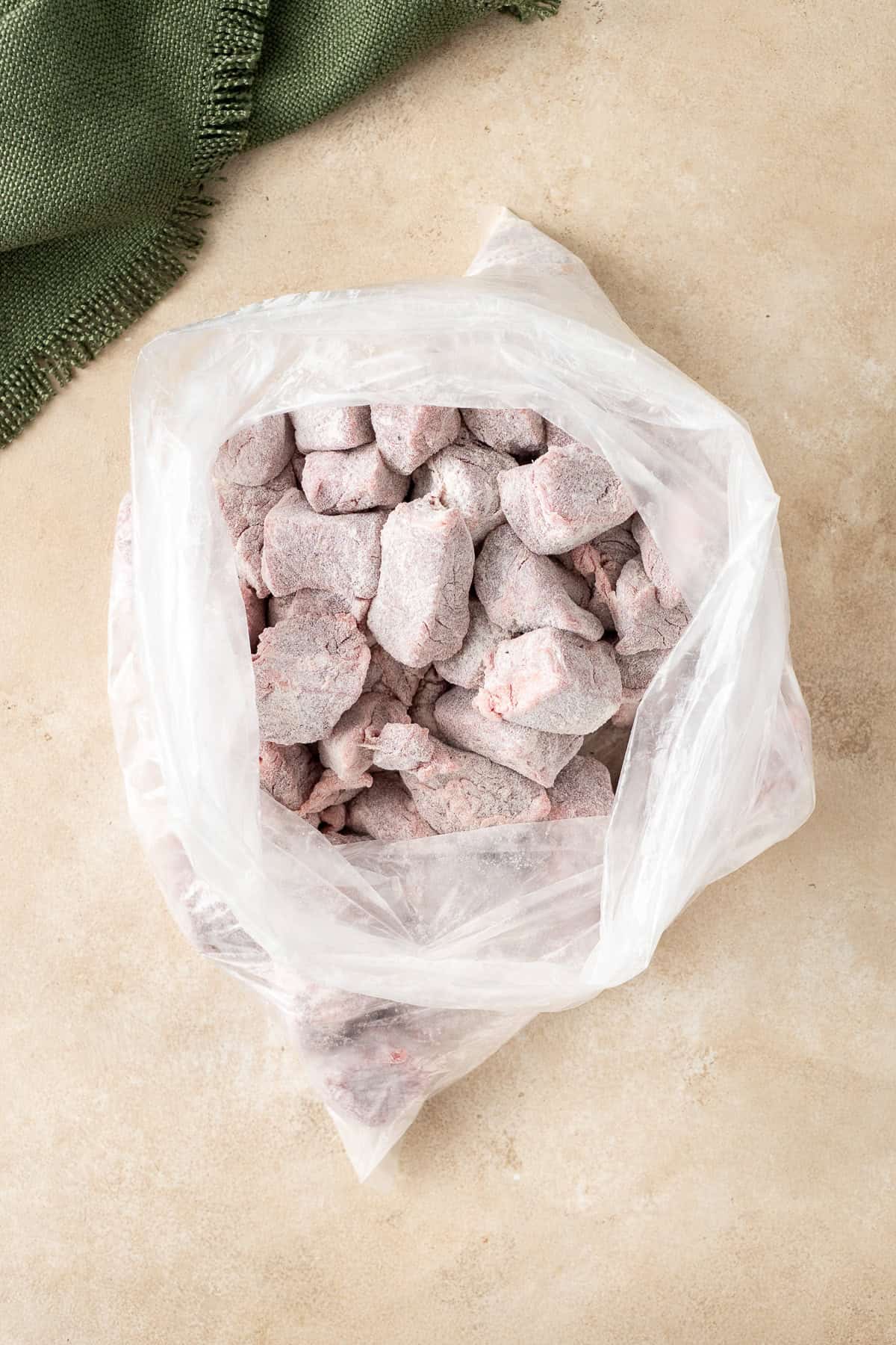 Coating the beef in flour in a zip-lock bag.