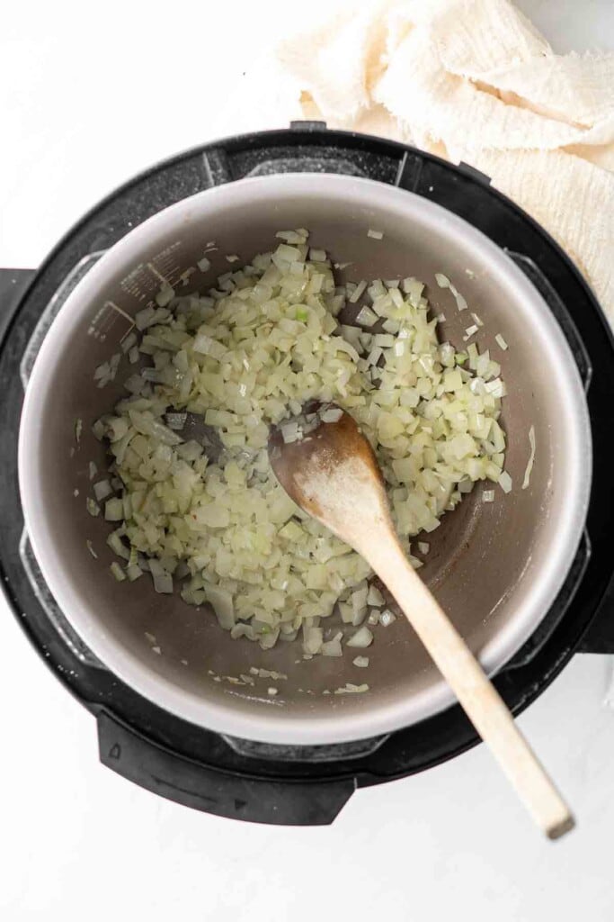 Sautéing onions and garlic in a slow cooker.