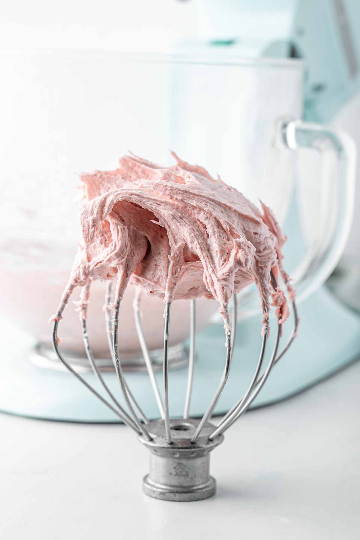 Creamy strawberry buttercream on a balloon whisk.