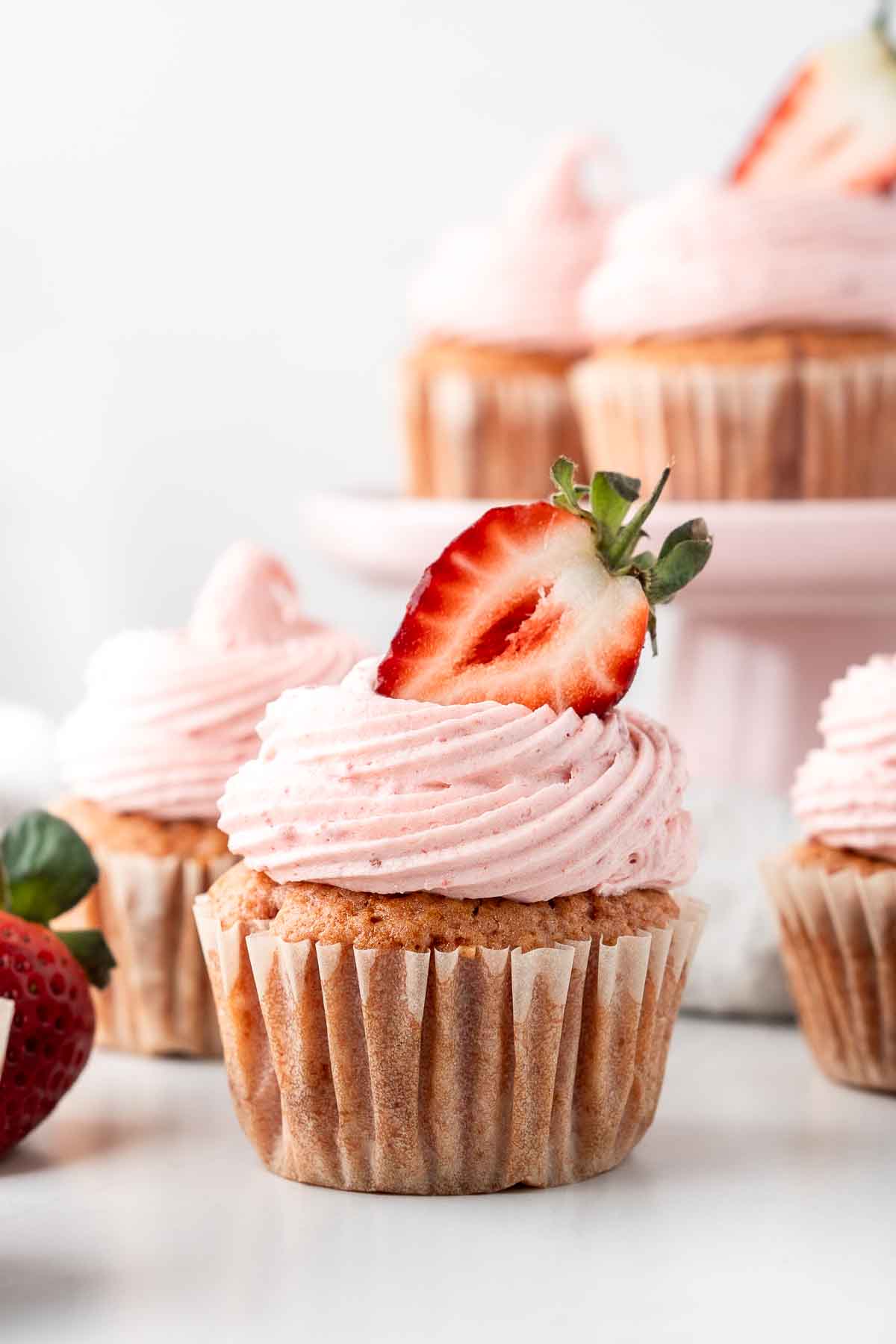 vegan strawberry cupcakes with strawberry buttercream and a fresh strawberry. 