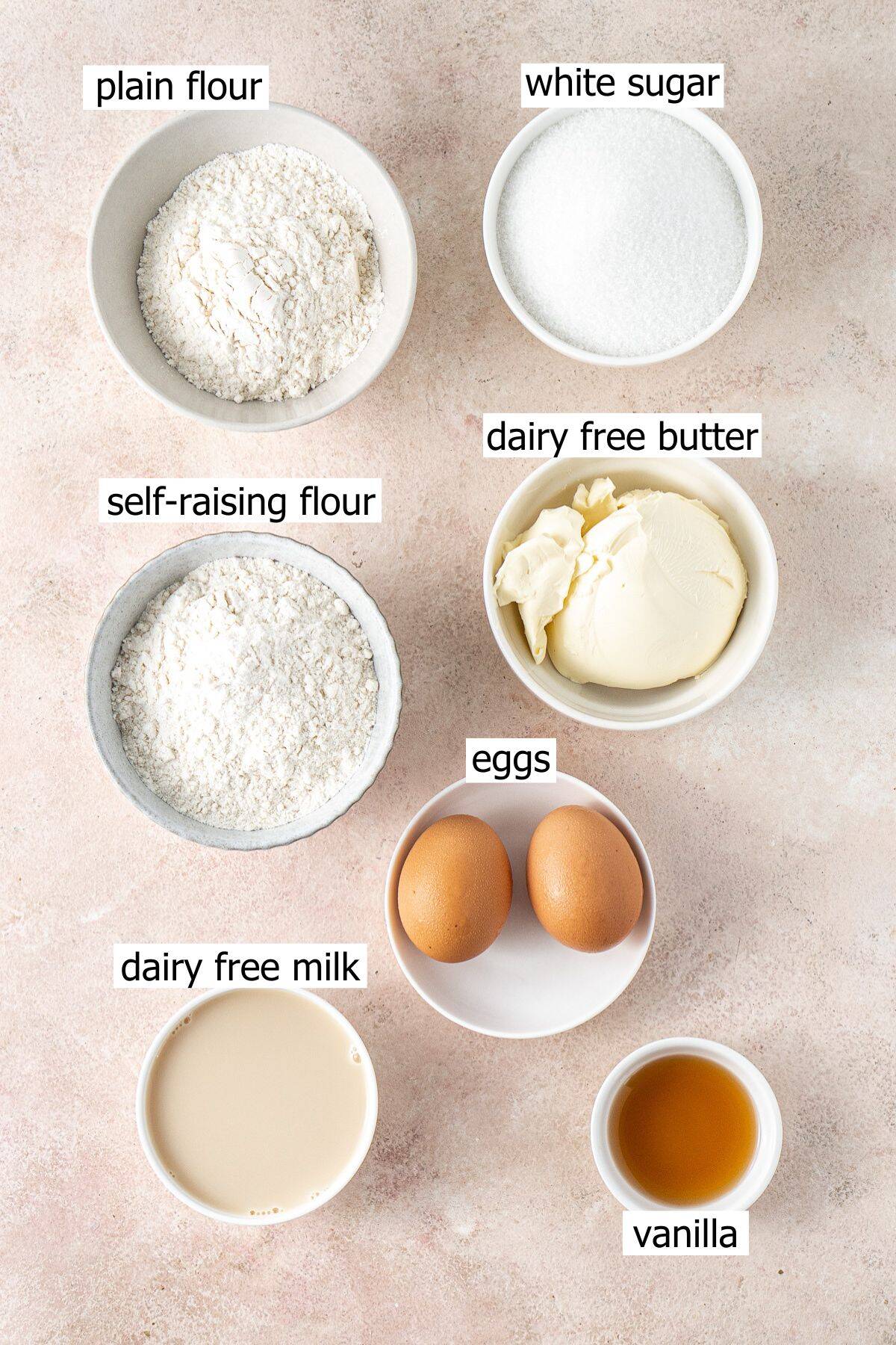 All ingredients needed to make dairy free cupcakes laid out in bowls.
