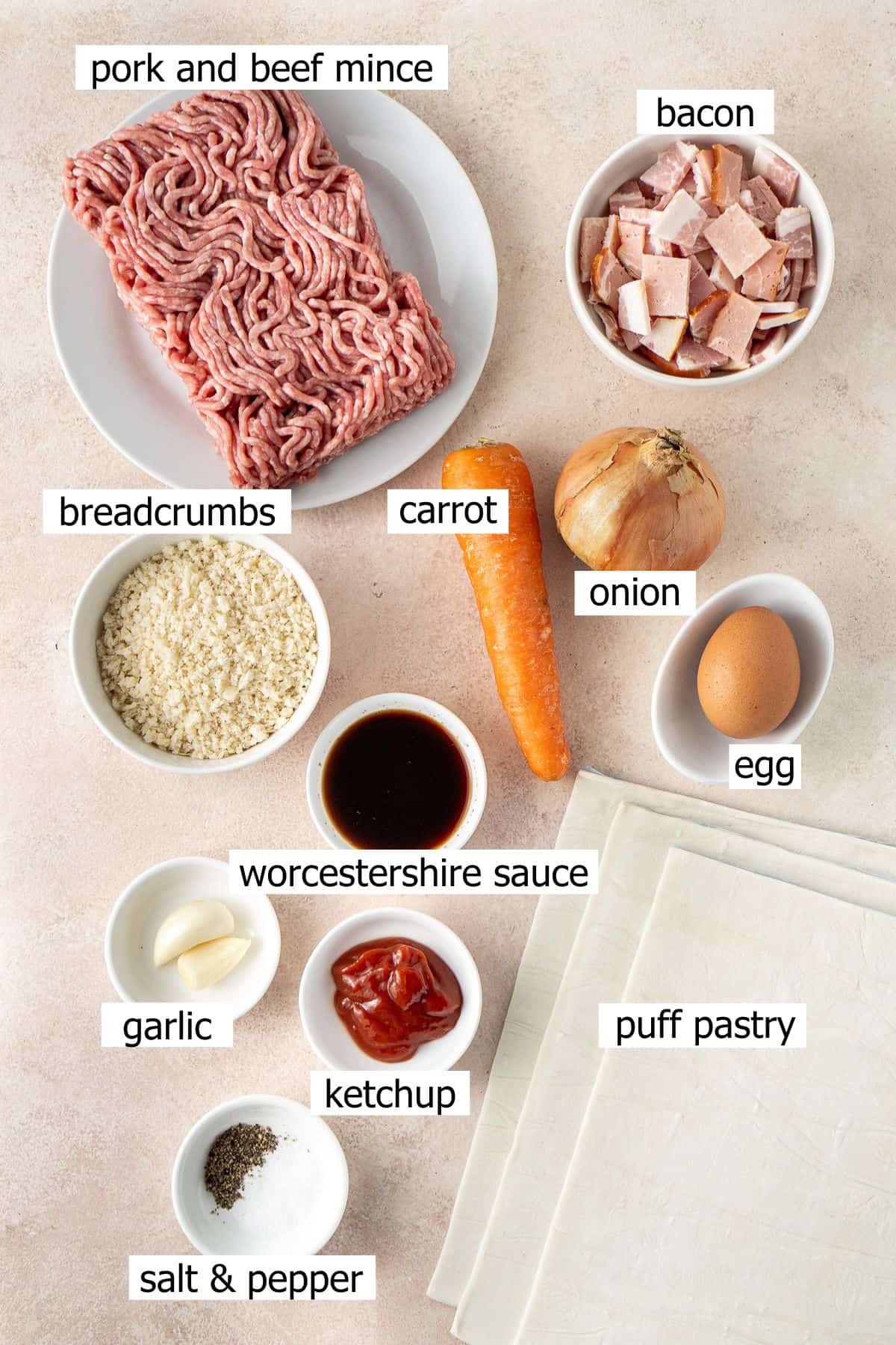 All ingredients needed to make sausage rolls laid out in bowls.