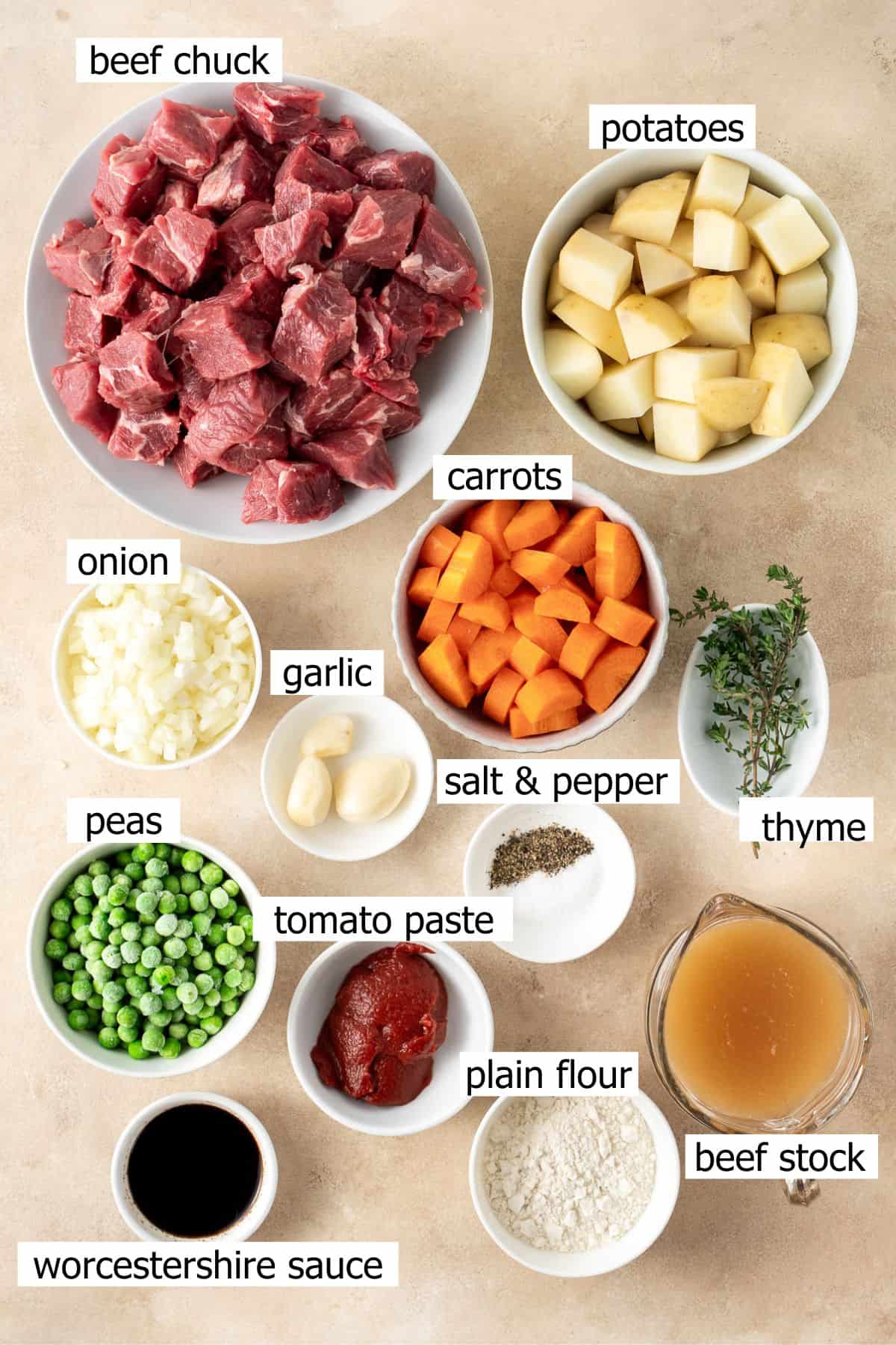 All ingredients needed to make slow cooker beef stew laid out in bowls.