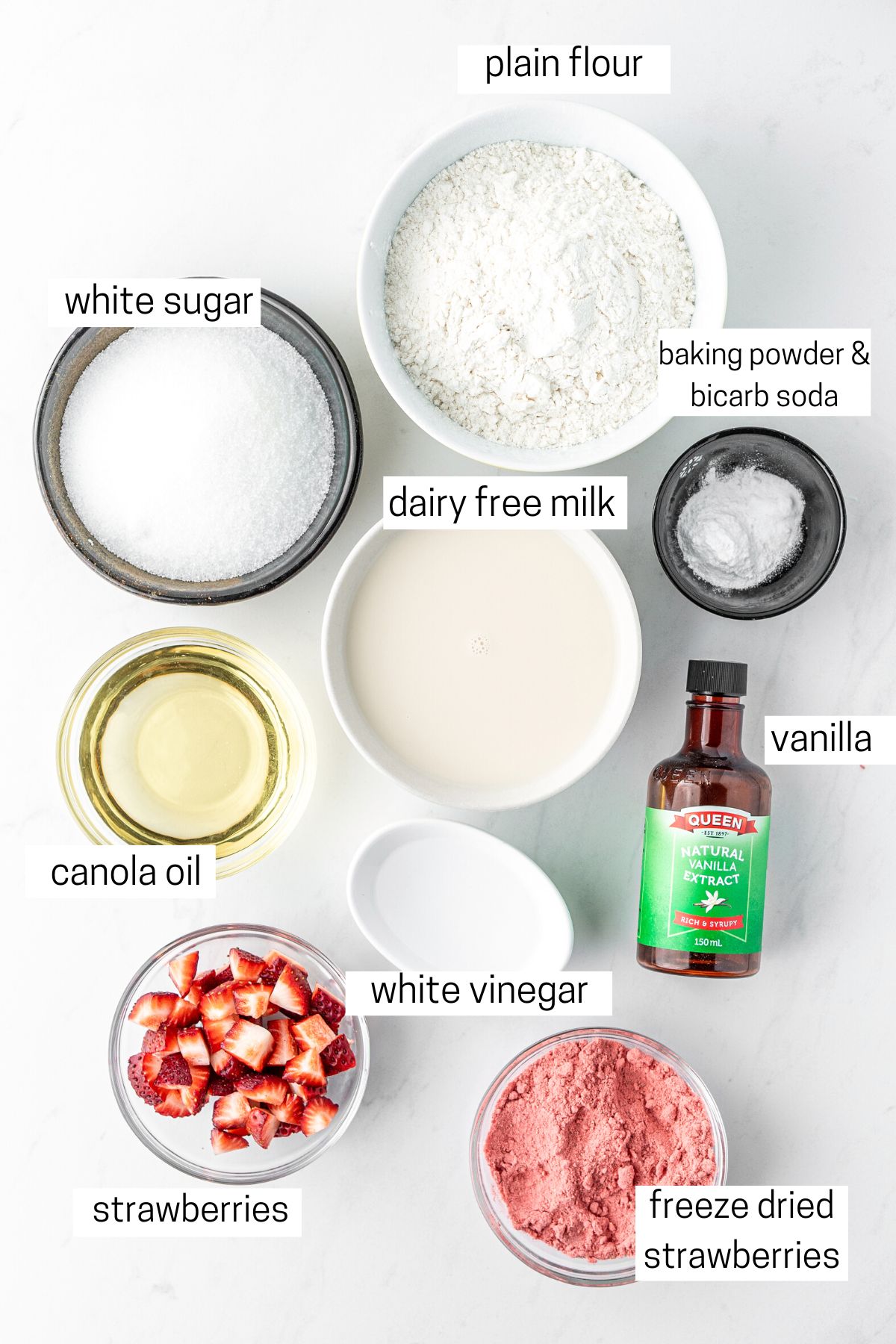 All ingredients needed to make strawberry cupcakes laid out in small bowls.
