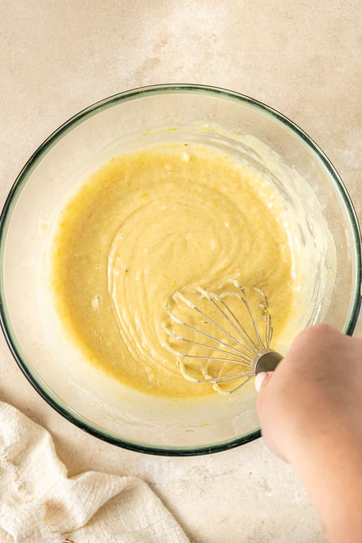 Mixing together the cake batter in a glass bowl.