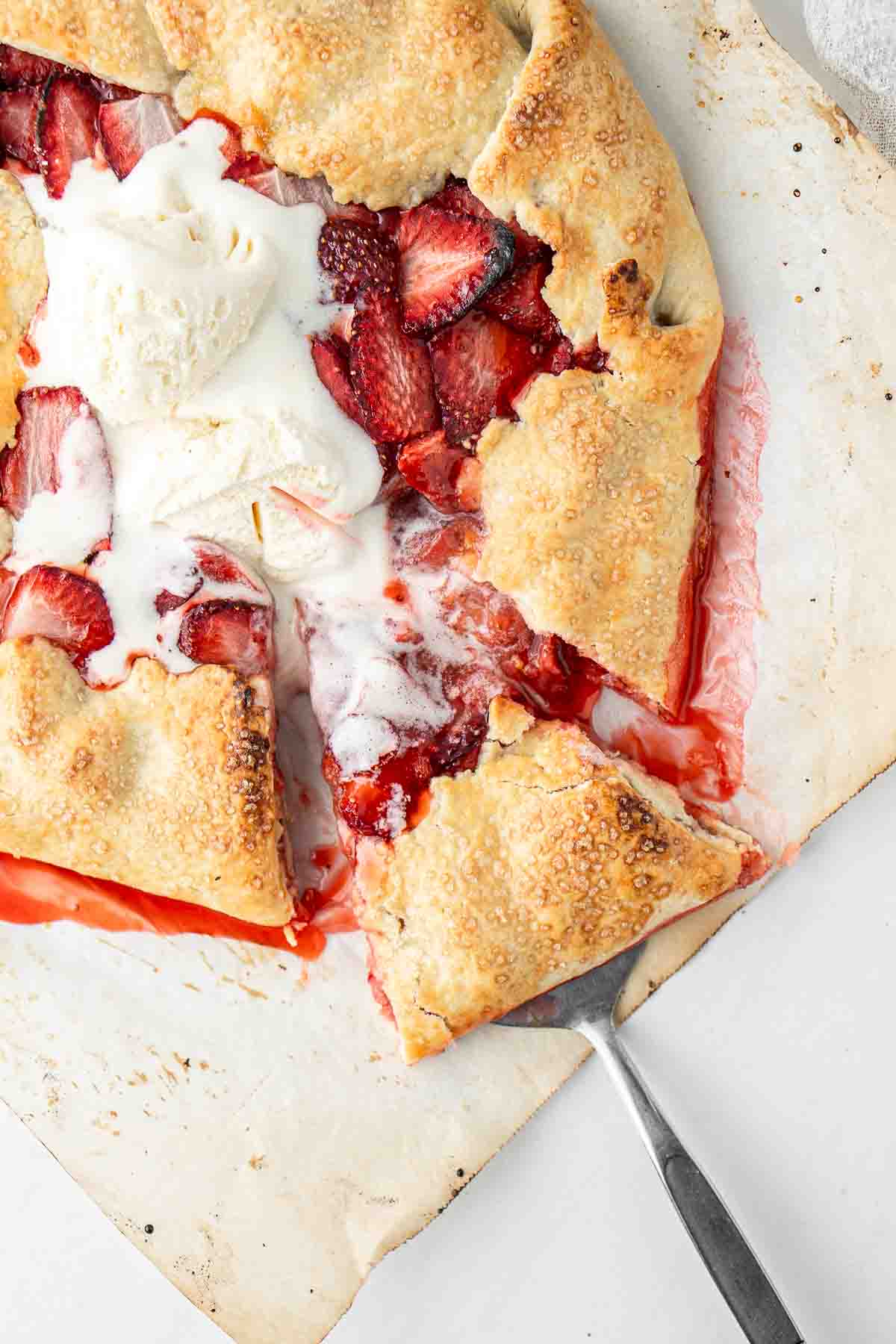 Close up of a slice of dairy free strawberry galette with vanilla ice cream. 