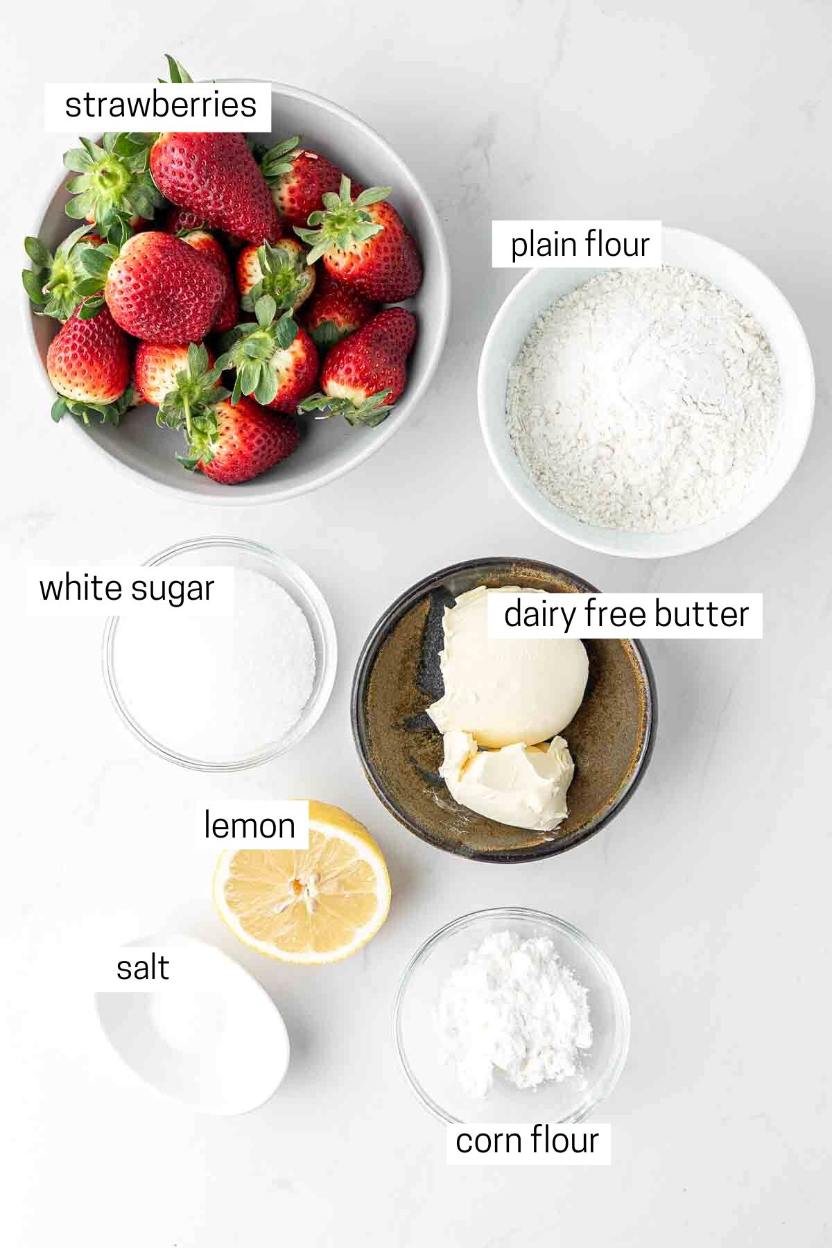 All ingredients for strawberry galette laid out in bowls.