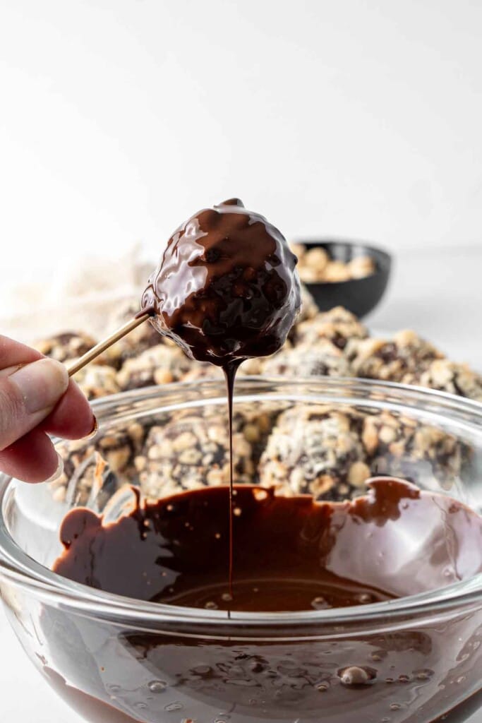 Dipping ferrero rochers in melted dark chocolate. 