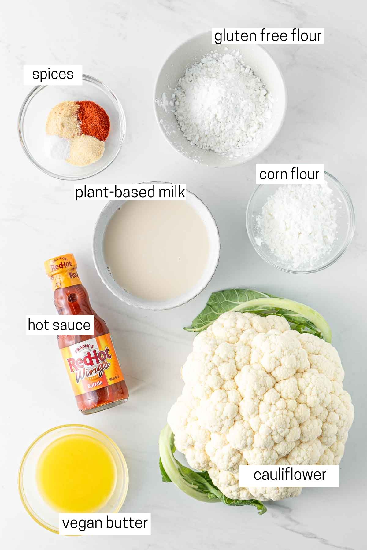 All ingredients needed for buffalo cauliflower laid out in small bowls.