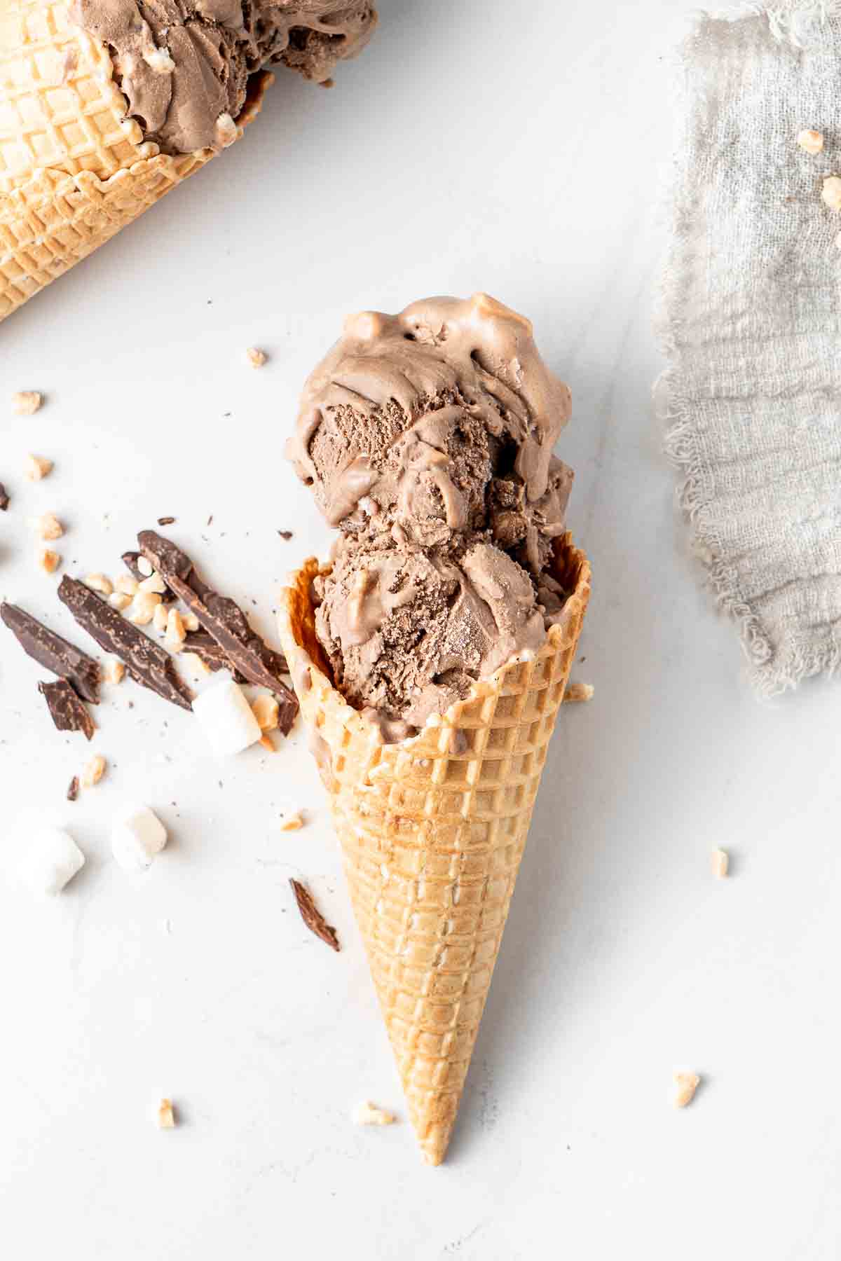 Two scoops of dairy free chocolate ice cream in a waffle cone.