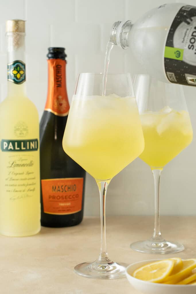 Topping the drink with soda water.