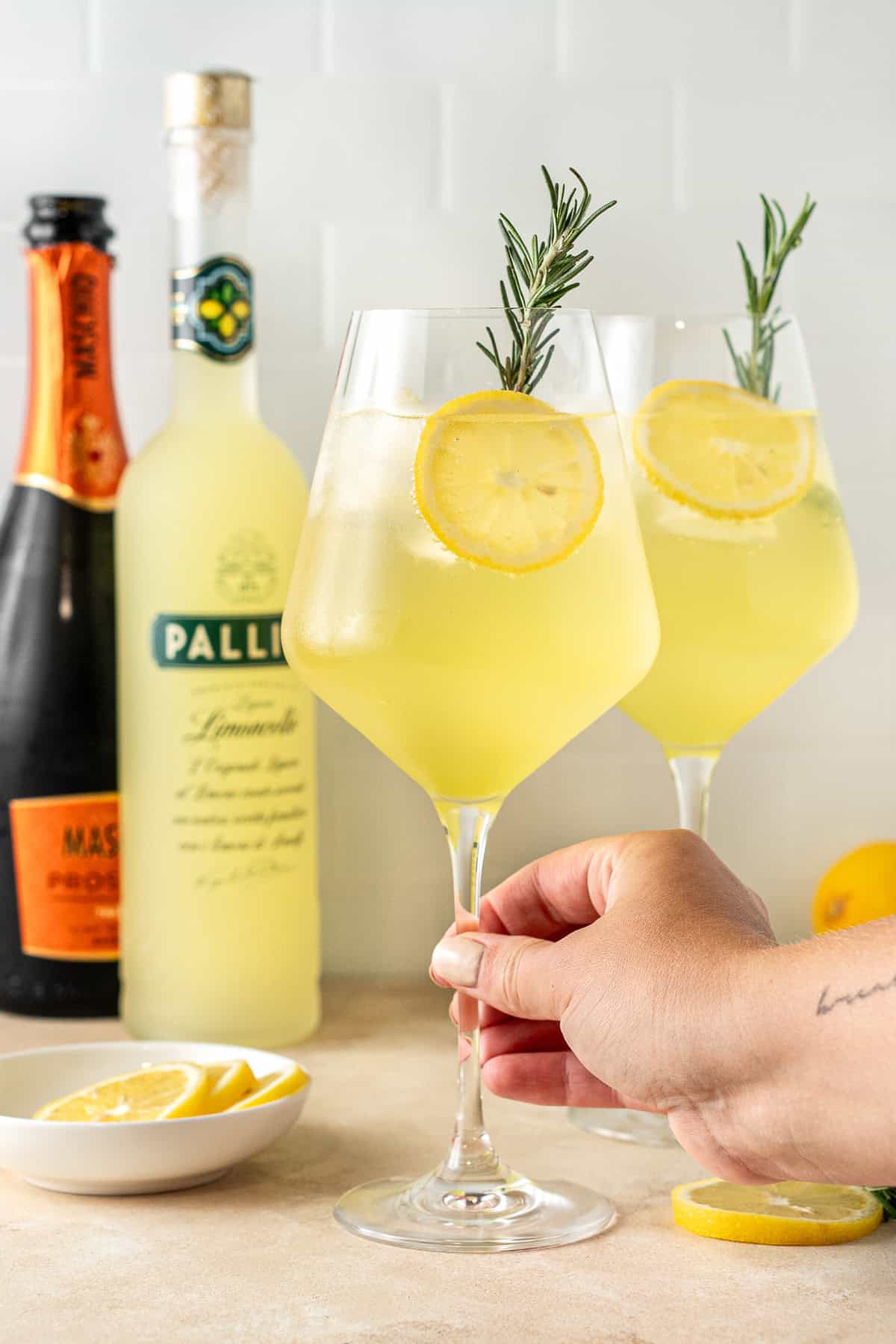 A hand holding the stem of the spritz glass.