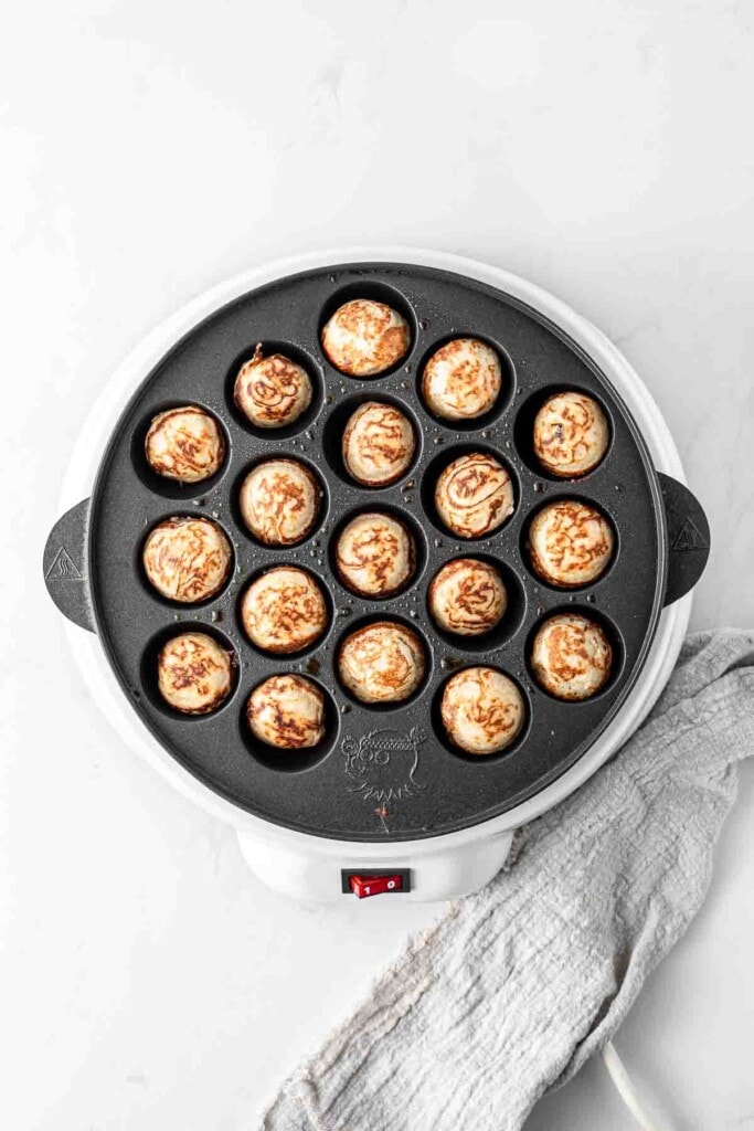 Cooked poffertjes in a pan.