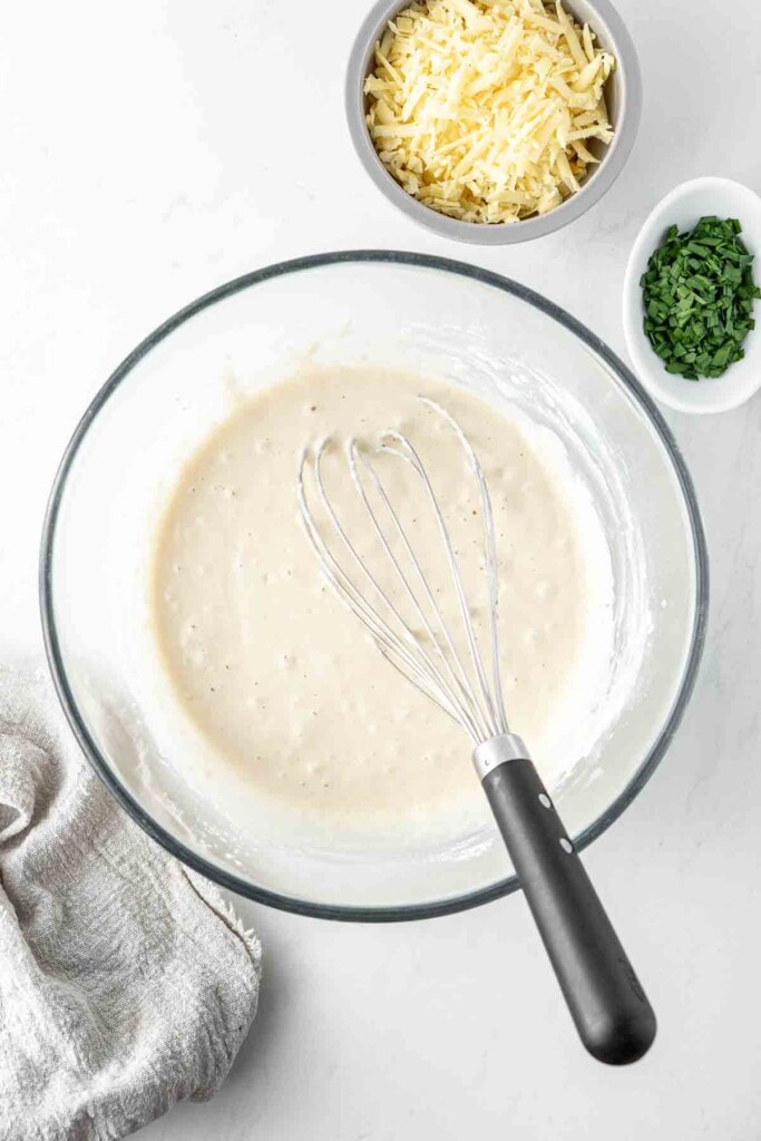 Whisking together the waffle batter in a glass bowl. 