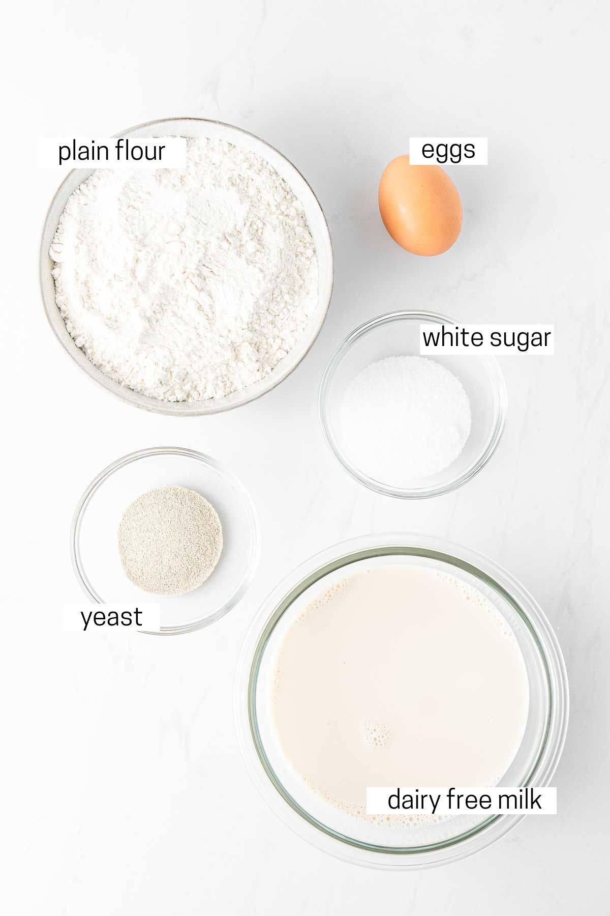 All ingredients needed for poffertjes laid out in bowls.
