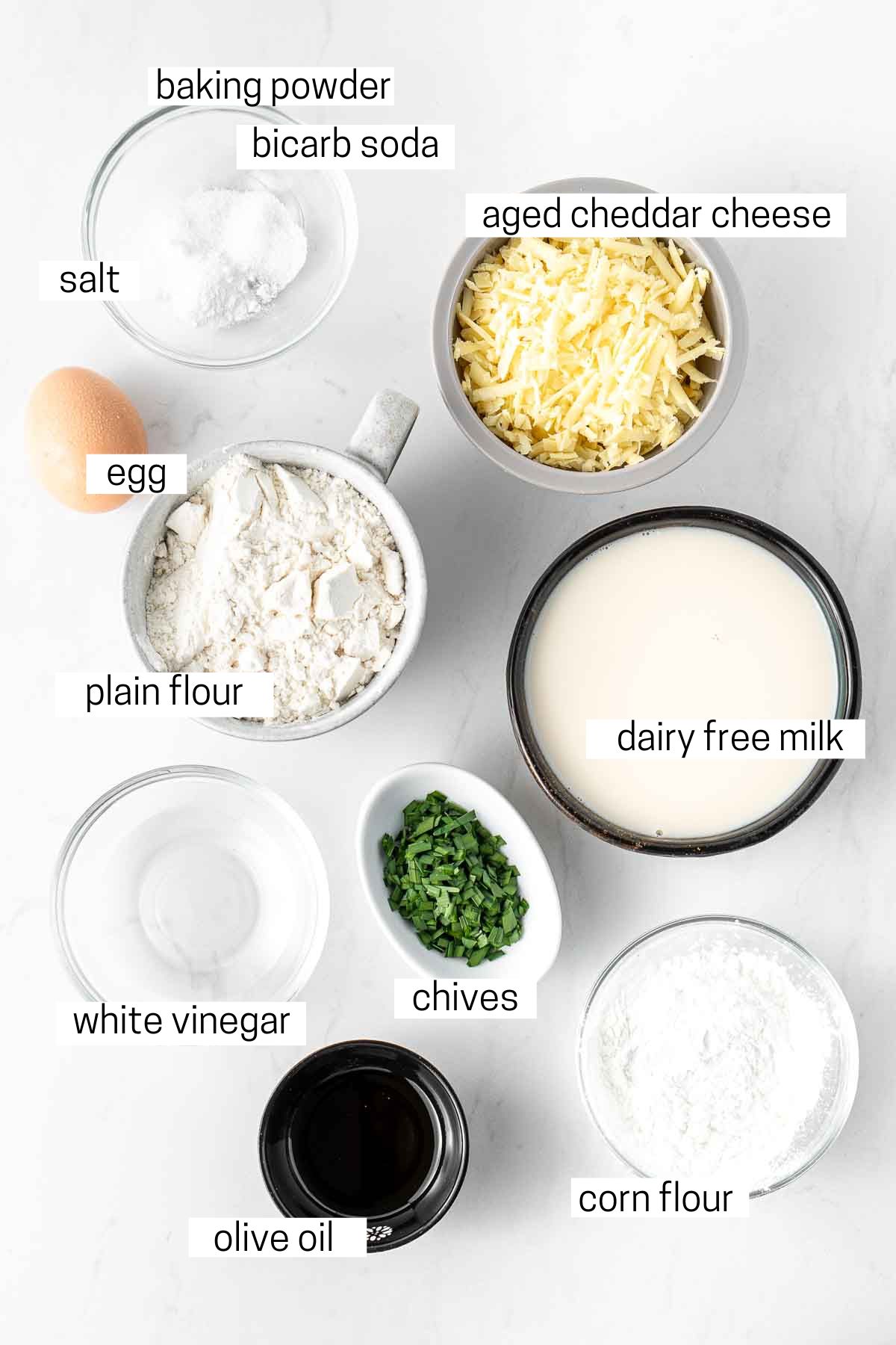 All ingredients needed for savoury waffles laid out in small bowls.