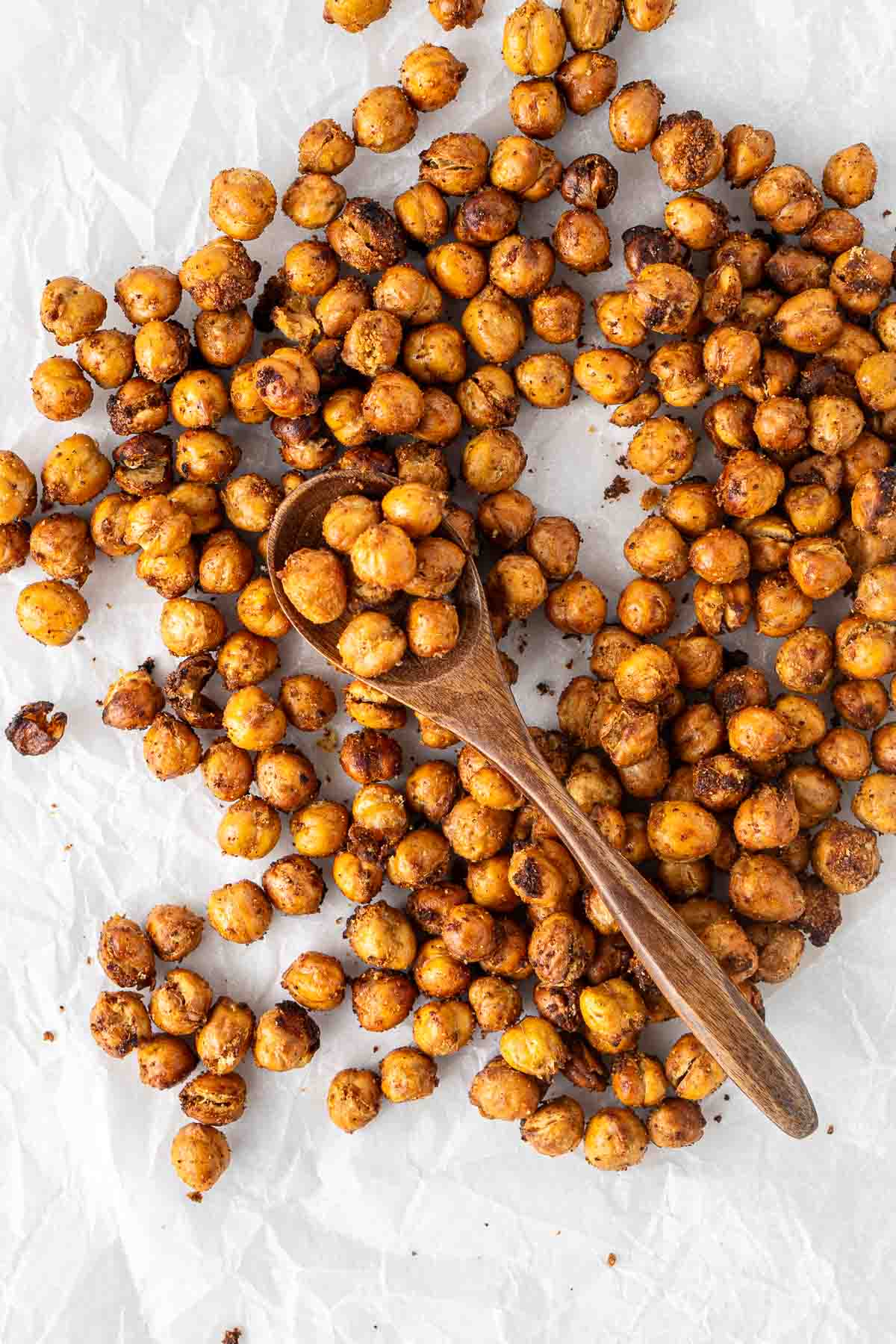 Crispy roasted chickpeas on a tray with a spoon.