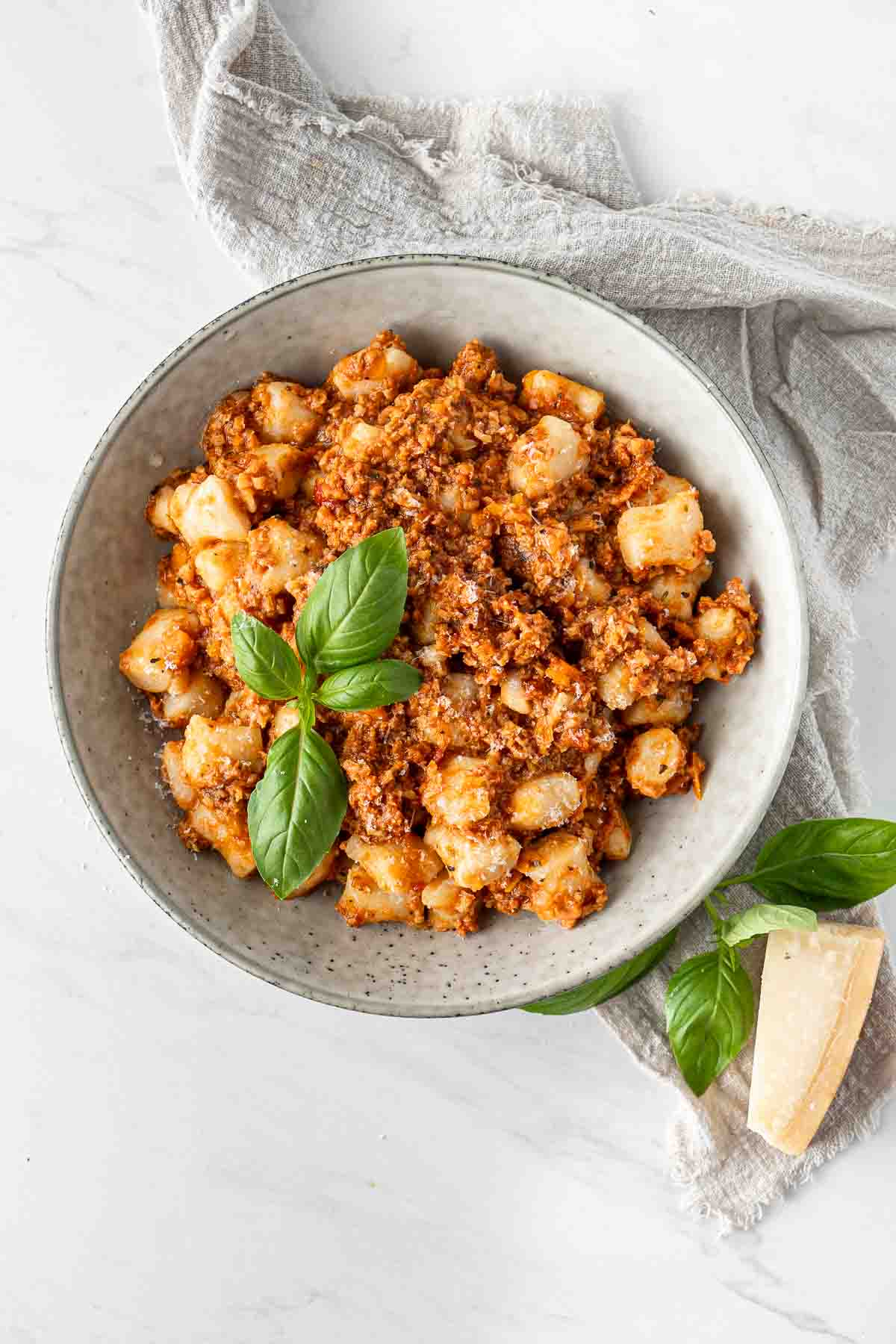 Vegetarian gnocchi bolognese in a bowl with fresh basil.