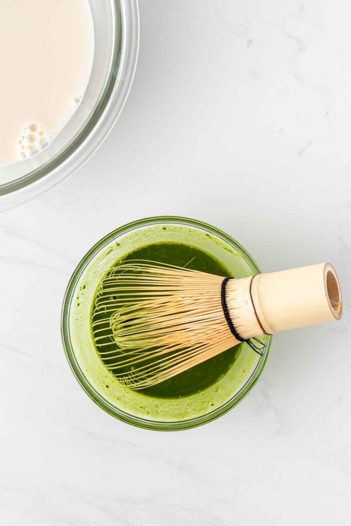 A bamboo matcha whisk in a small bowl.