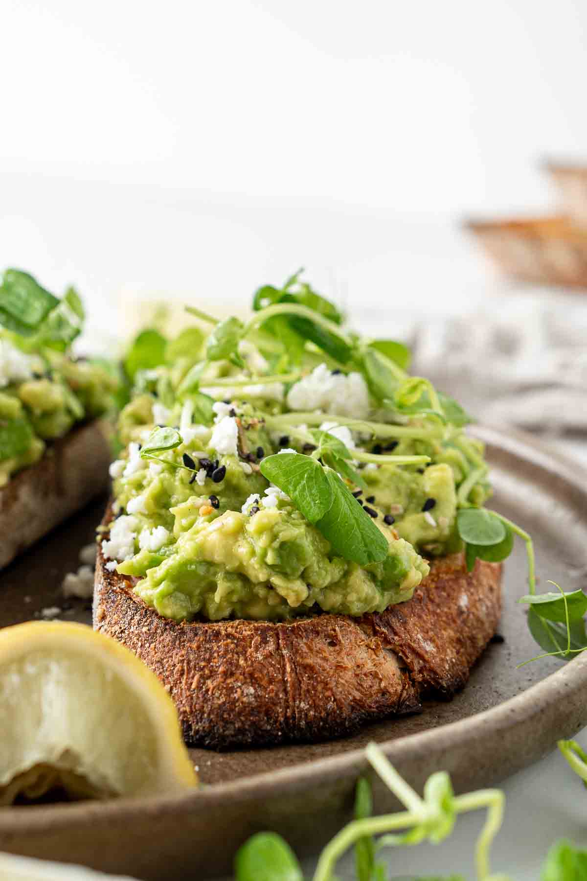 Close up of chunky toast with a pile of smashed avocado on top.