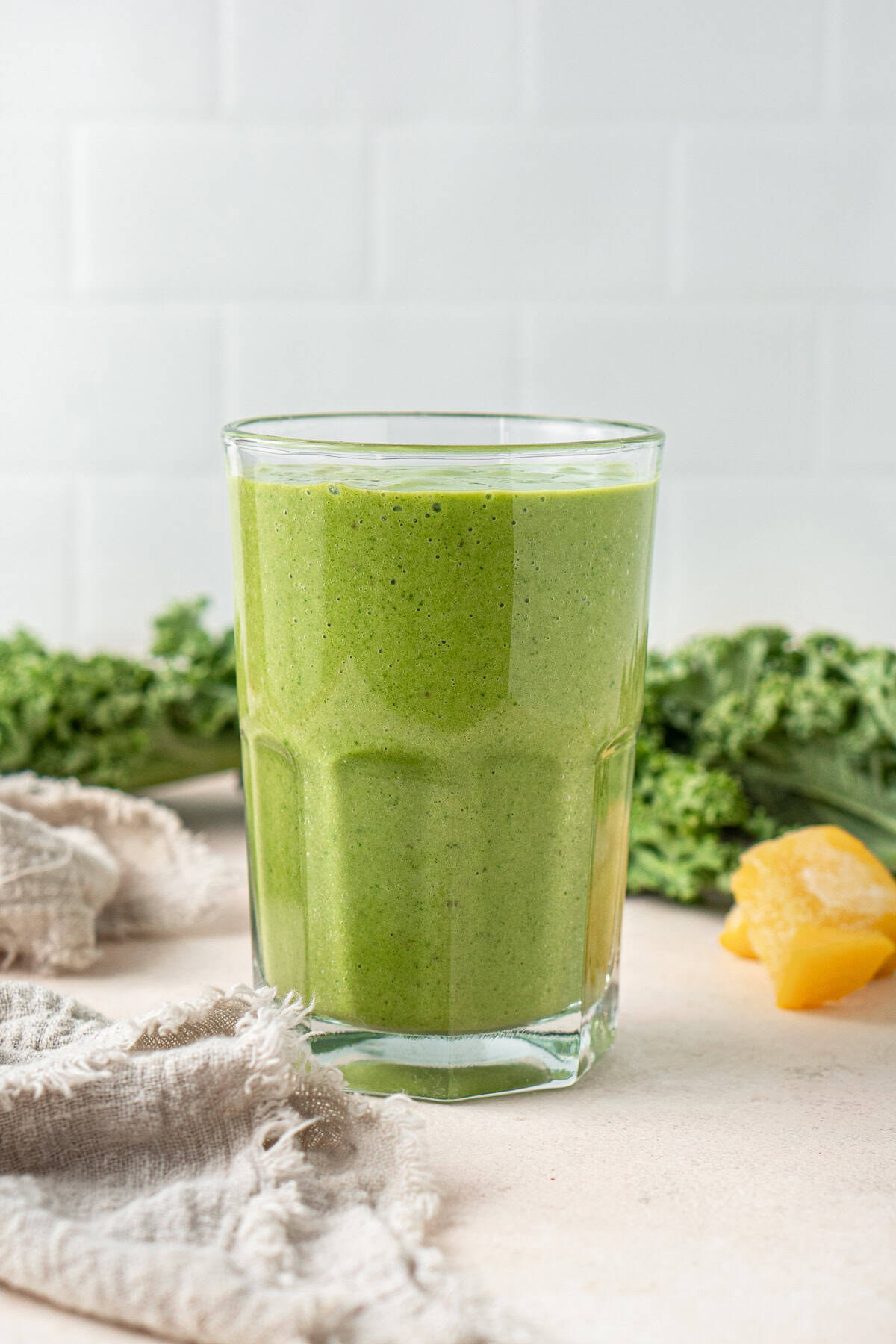 A glass of mango kale smoothie.