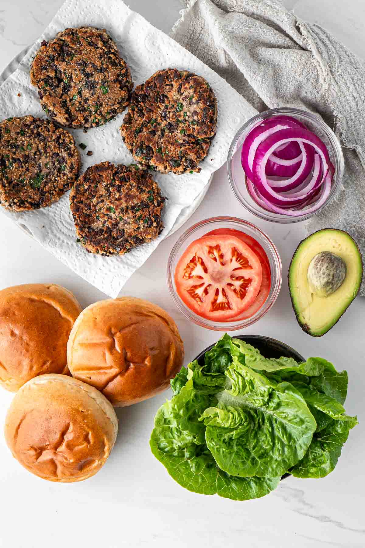 Cooked black bean burgers with all ingredients to assemble.