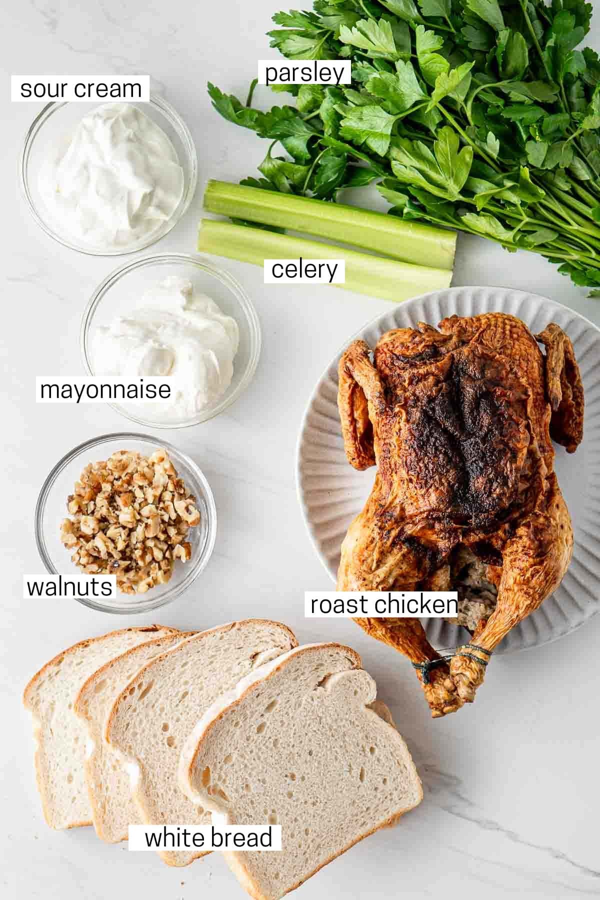 All ingredients for chicken salad sandwiches laid out in bowls.