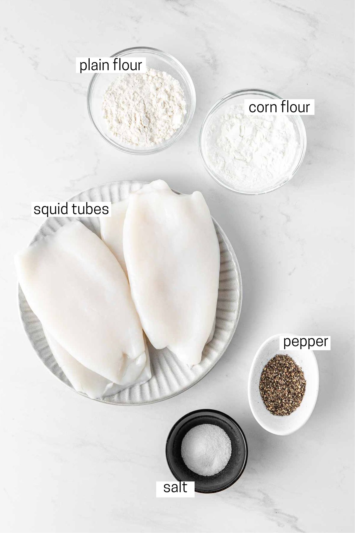 All ingredients needed to make salt and pepper squid laid out in bowls.