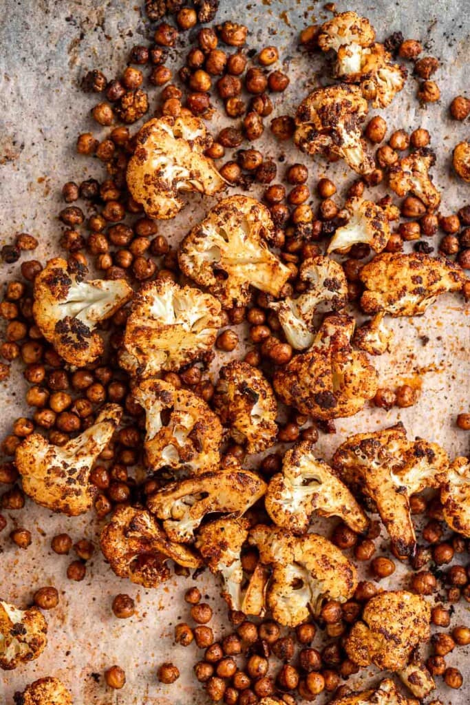 Roasted cauliflower and chickpeas on a baking tray.