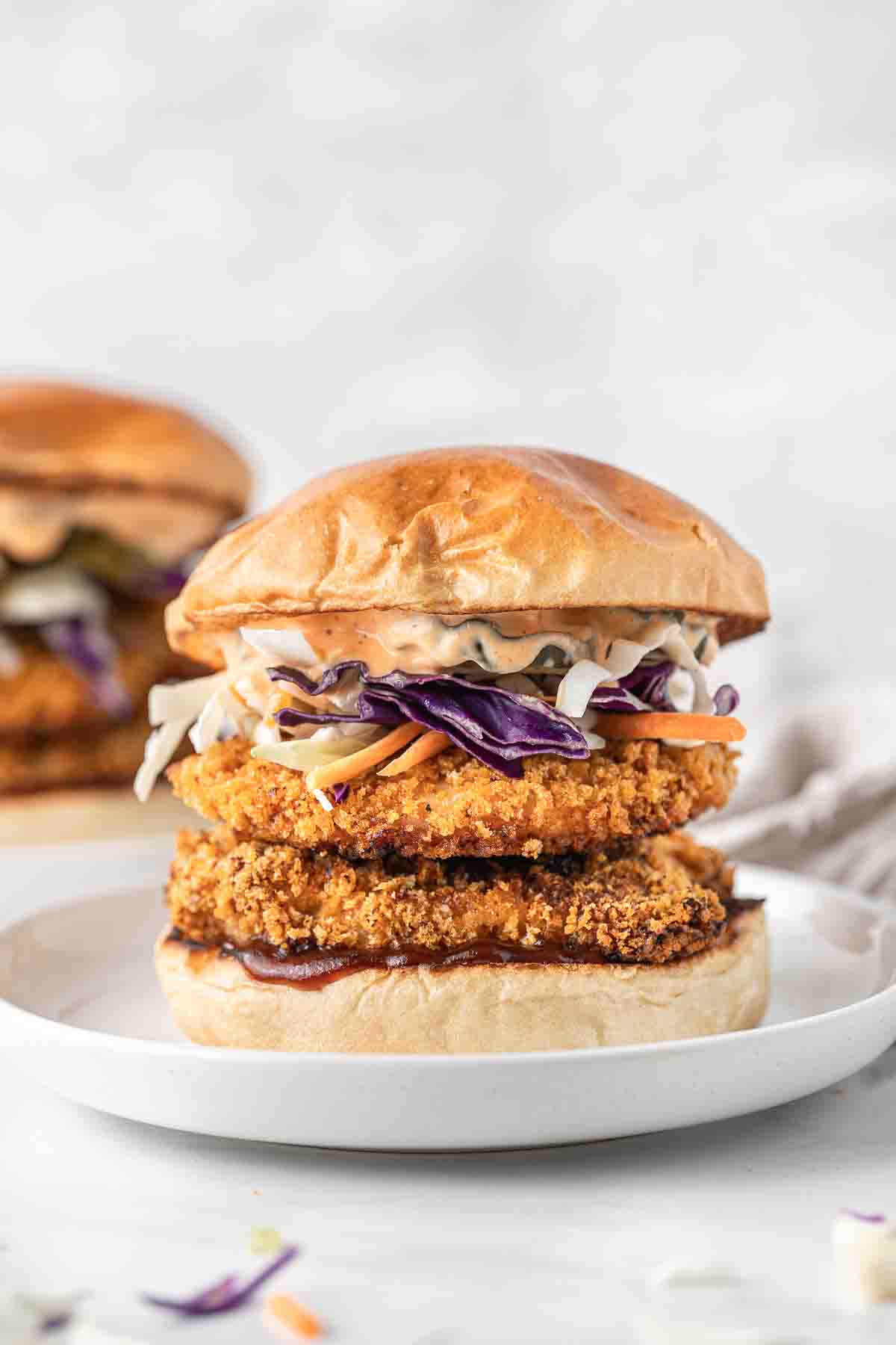 Spicy chicken burger on a white plate.