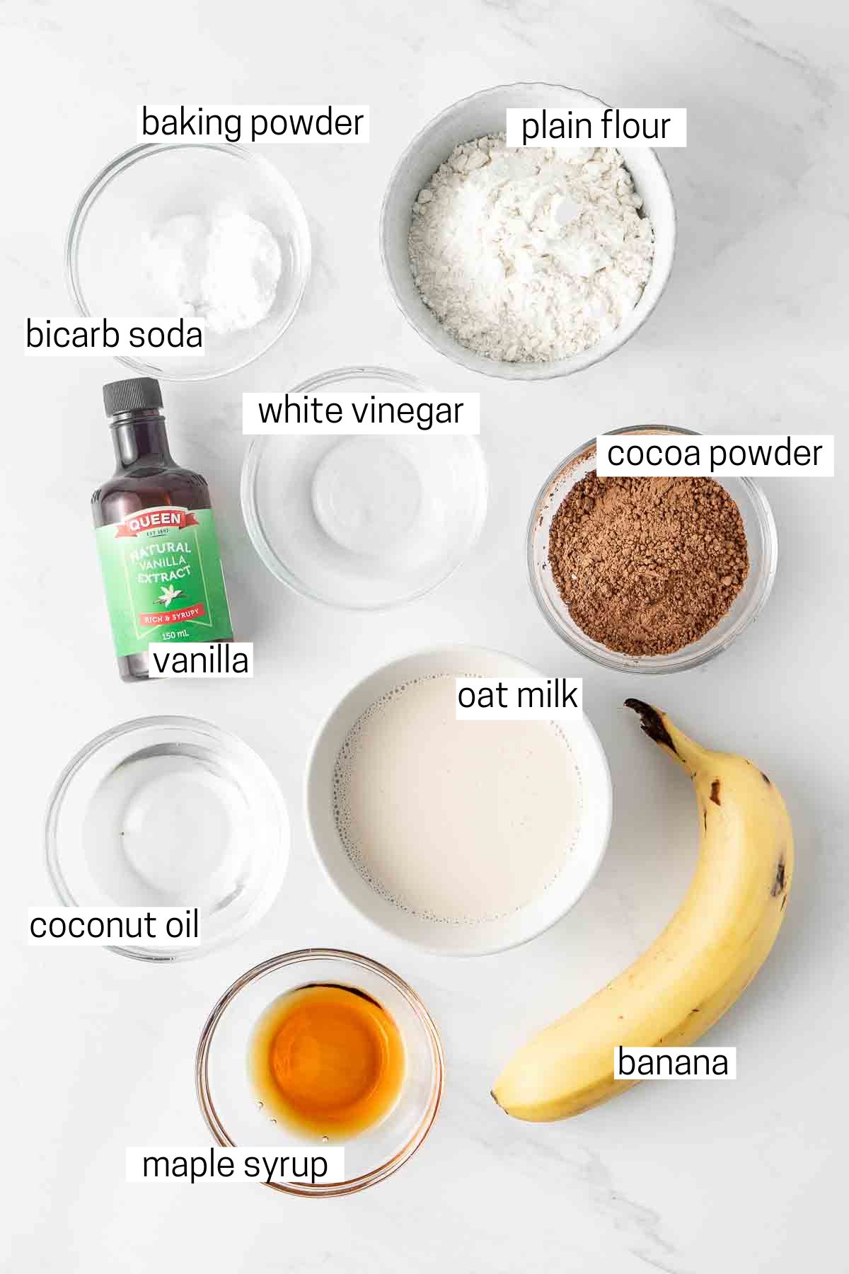 All ingredients needed to make chocolate pancakes laid out in small bowls.