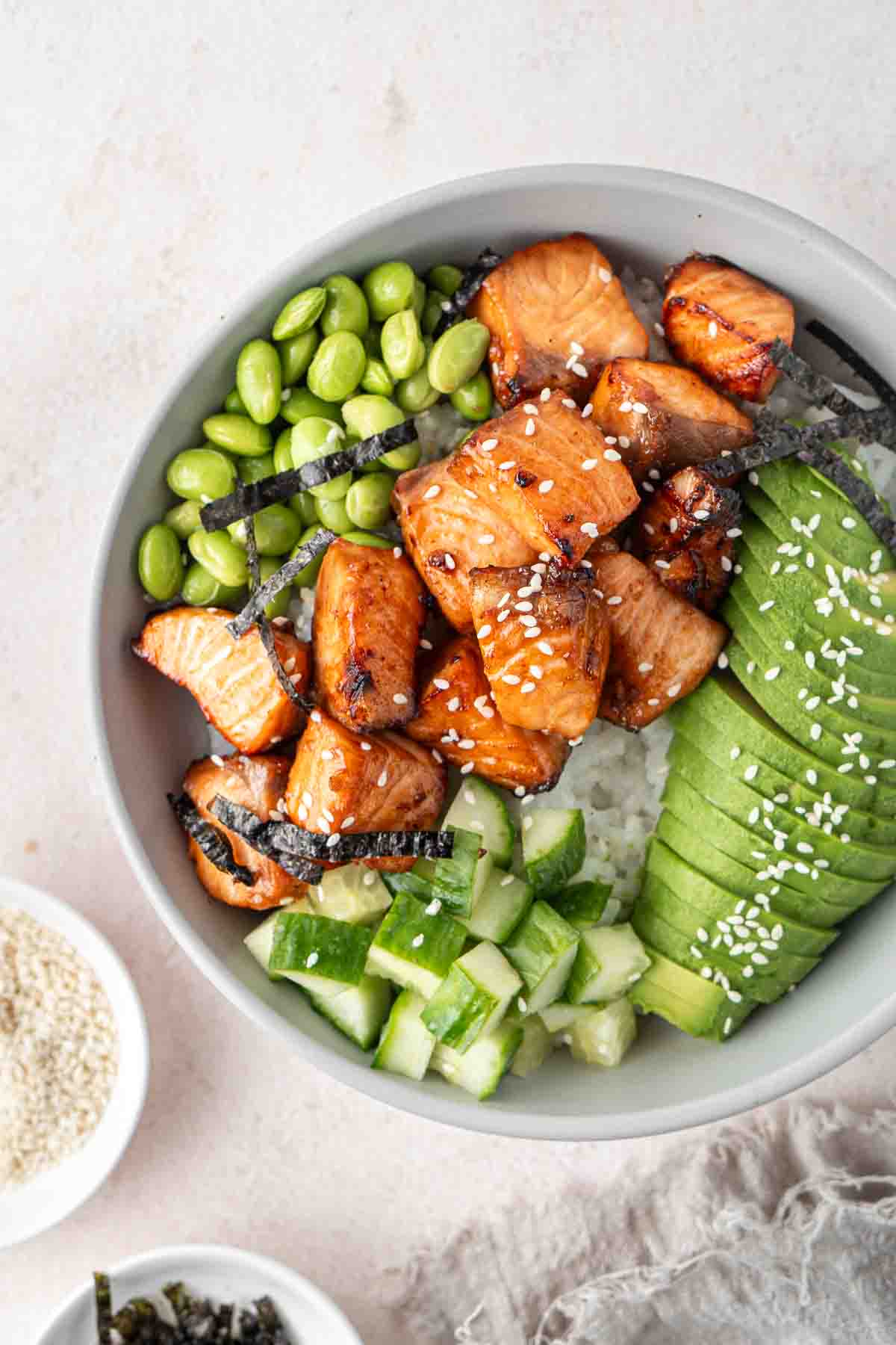 Close up of air fryer salmon in a bowl with rice and toppings. 