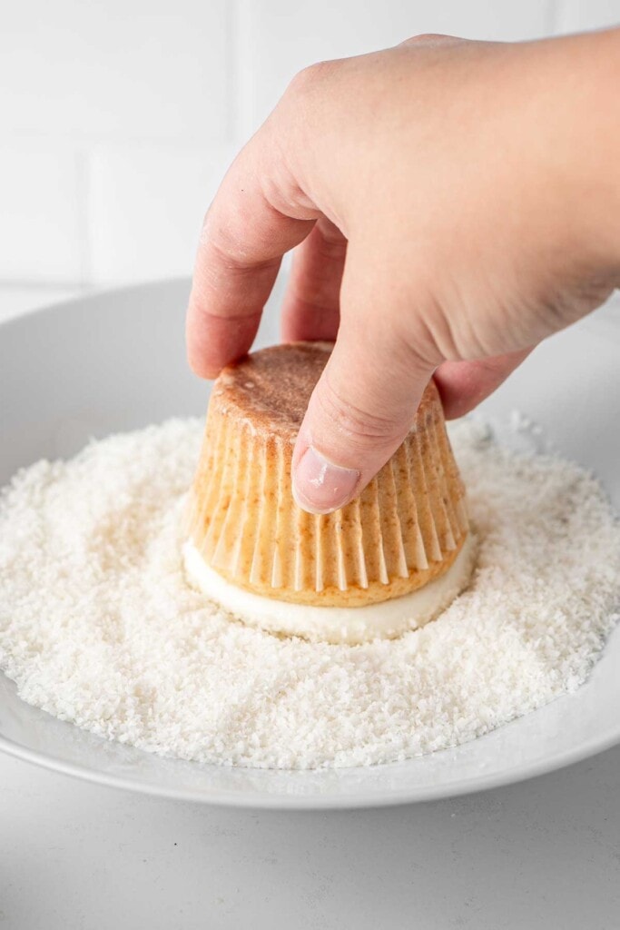 Dipping coconut buttercream into desiccated coconut.