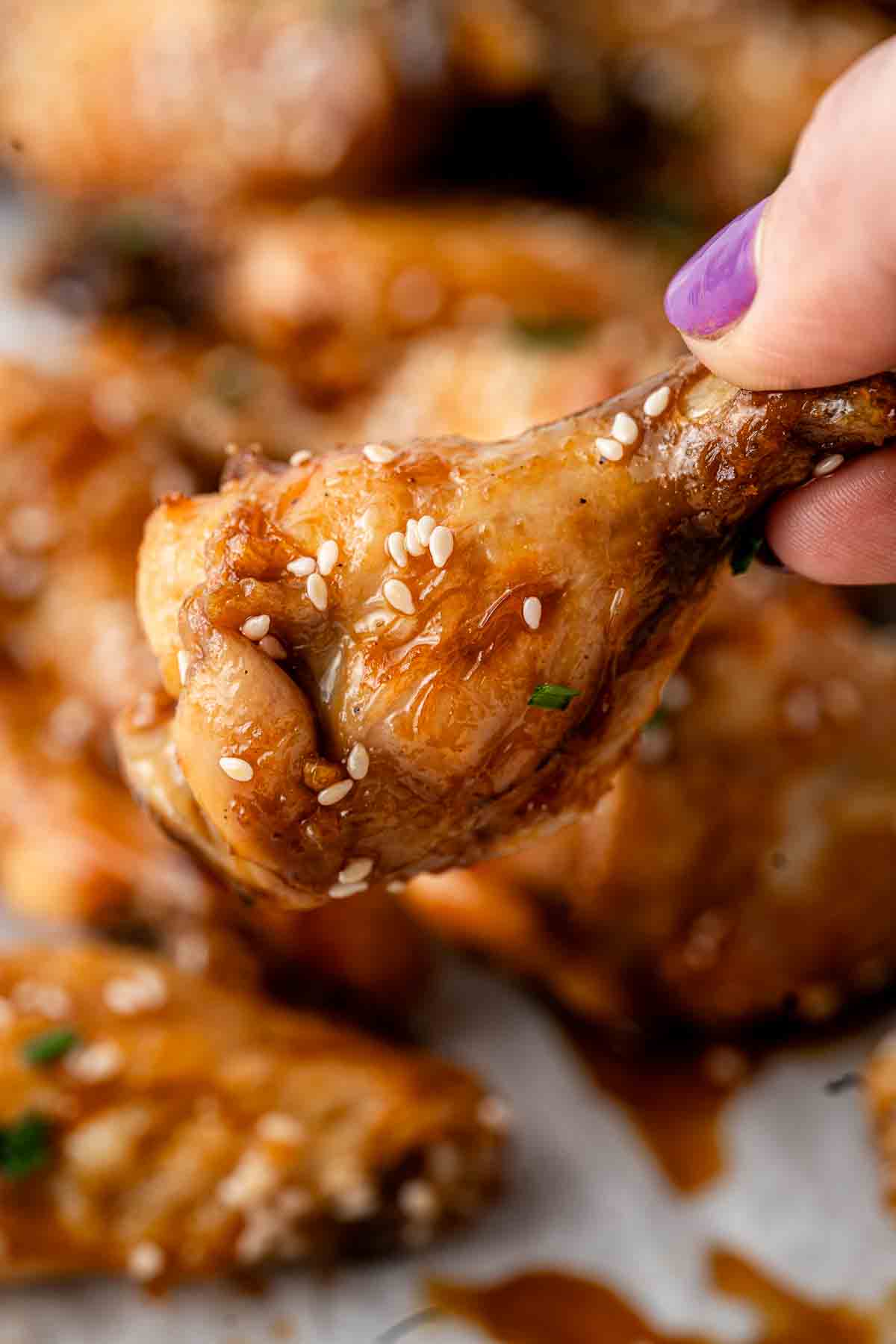 Close up of a sticky, honey garlic chicken wing.
