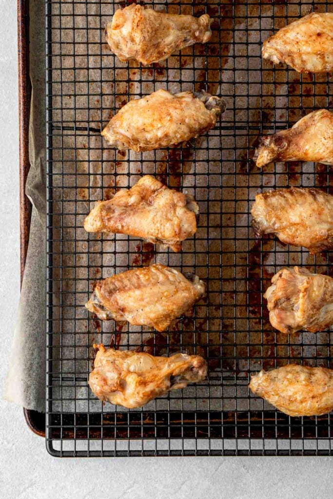 Crispy baked chicken wings on a baking tray.