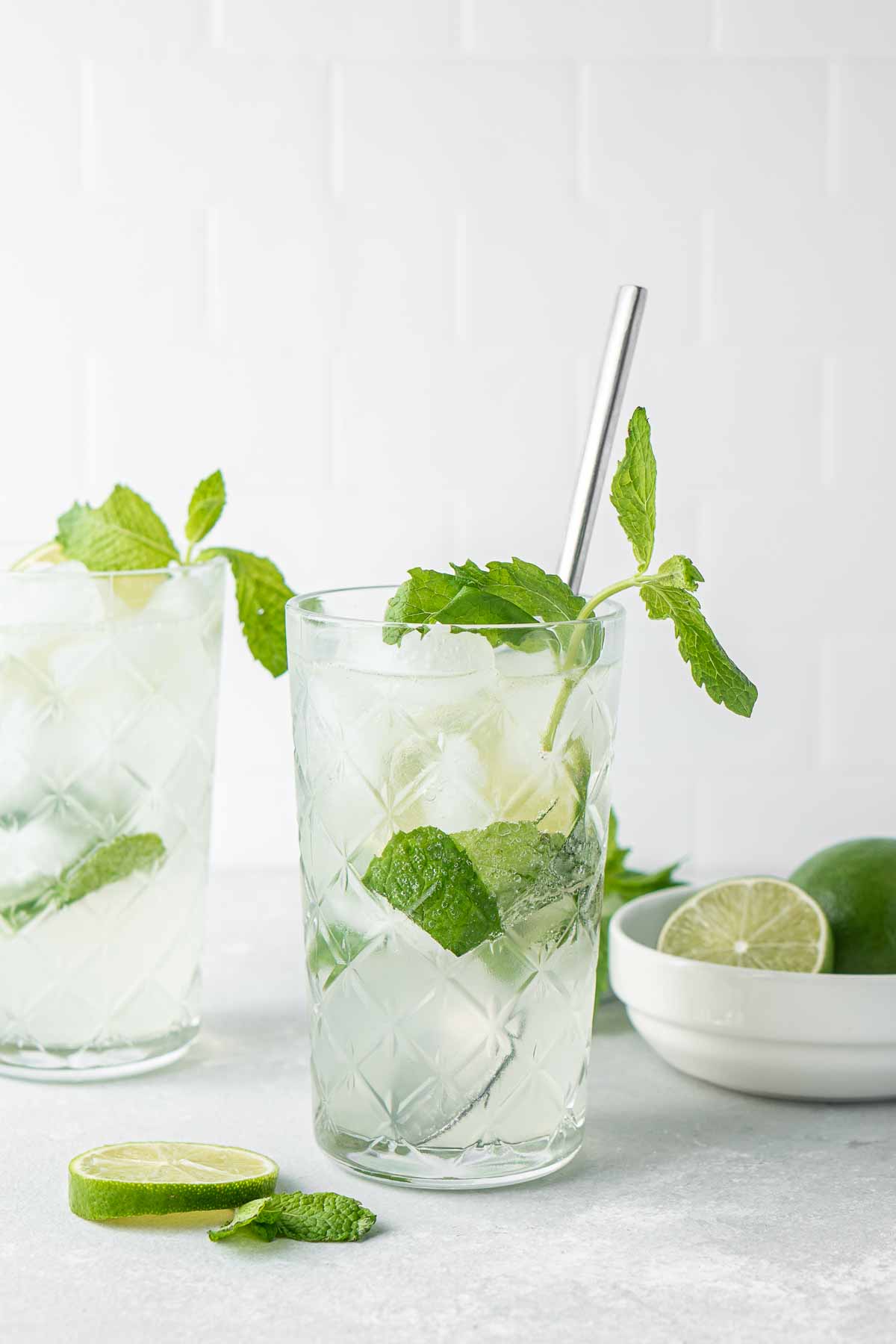 Non alcoholic mojitos in tall glasses with fresh mint and lime.