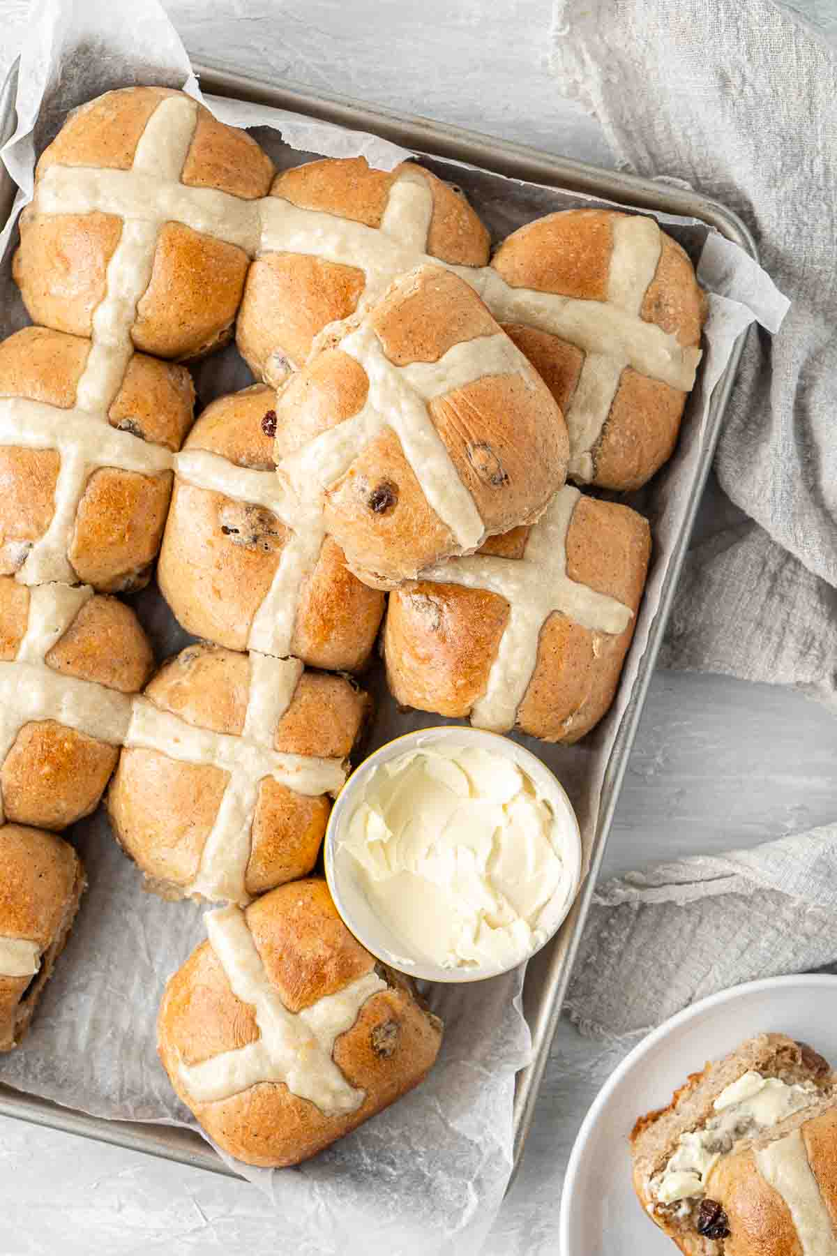 Hot cross buns on a tray with dairy free butter.