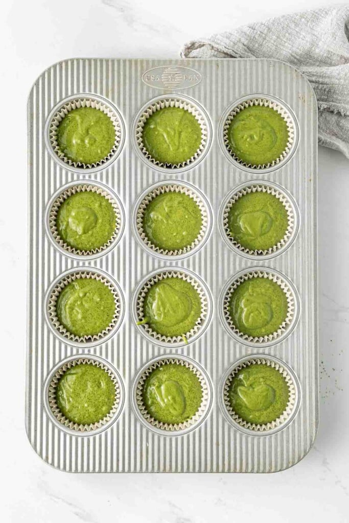 Green matcha cupcake batter in a cupcake tray ready to bake.