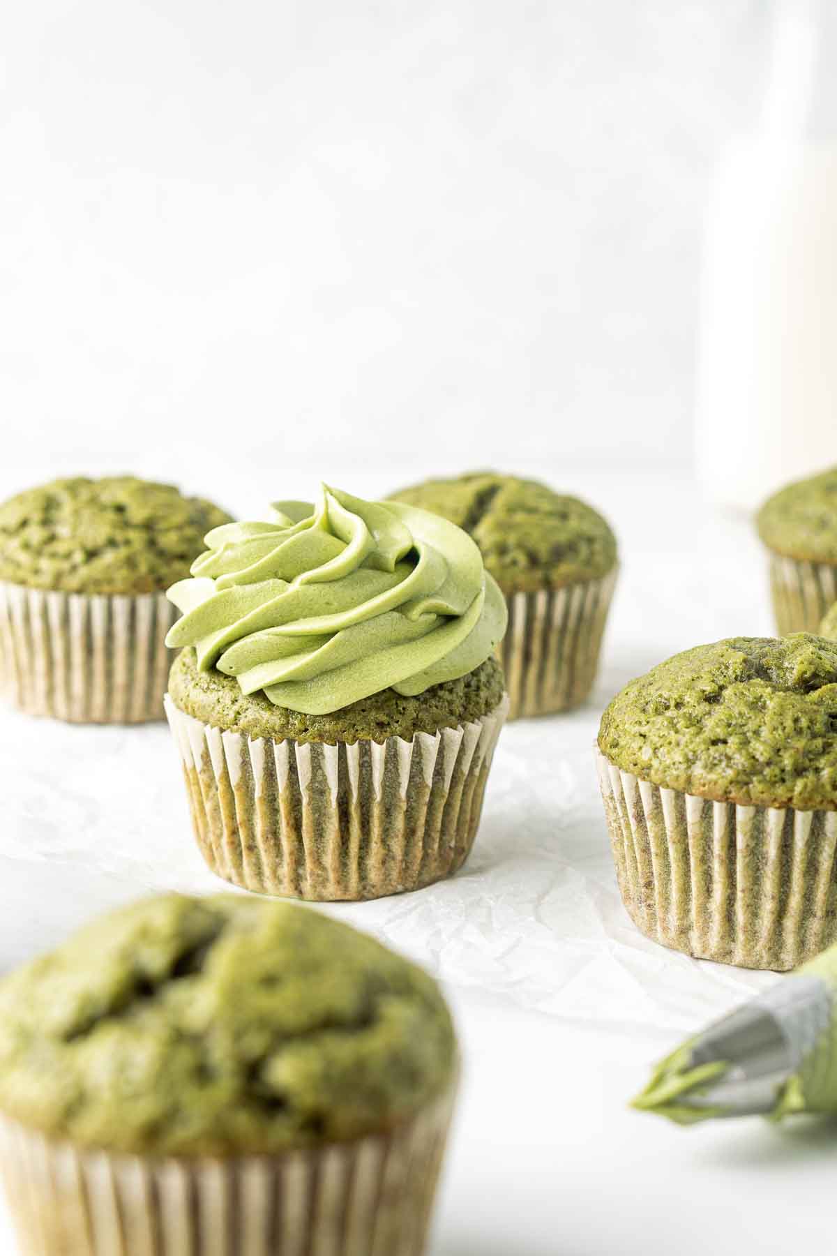 Vegan matcha cupcakes being frosted.