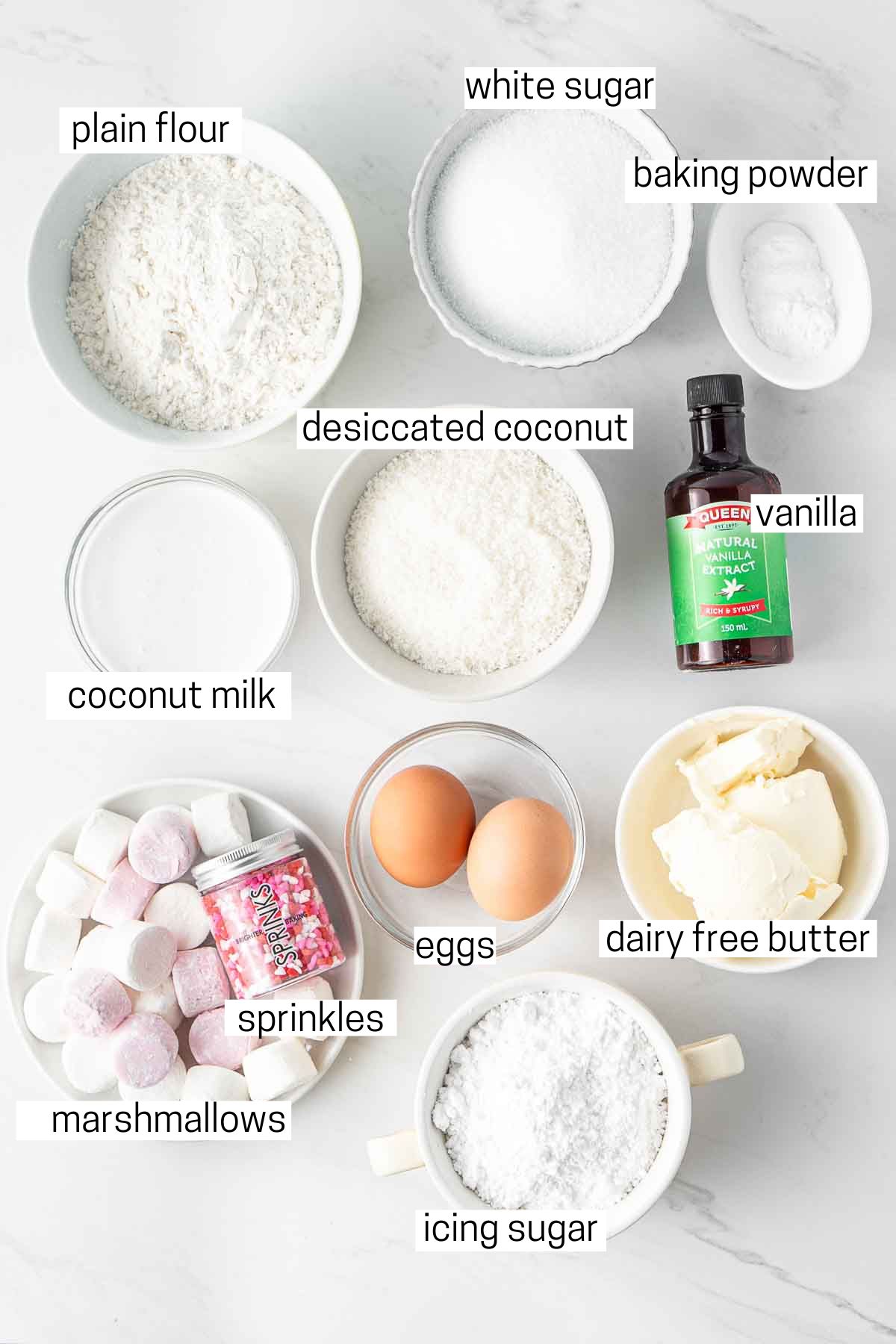 All ingredients needed to make easter bunny cupcakes laid out in small bowls.