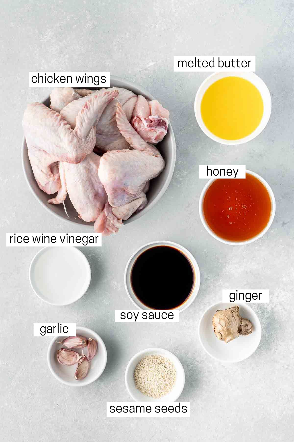 All ingredients needed to make honey garlic chicken wings laid out in small bowls.